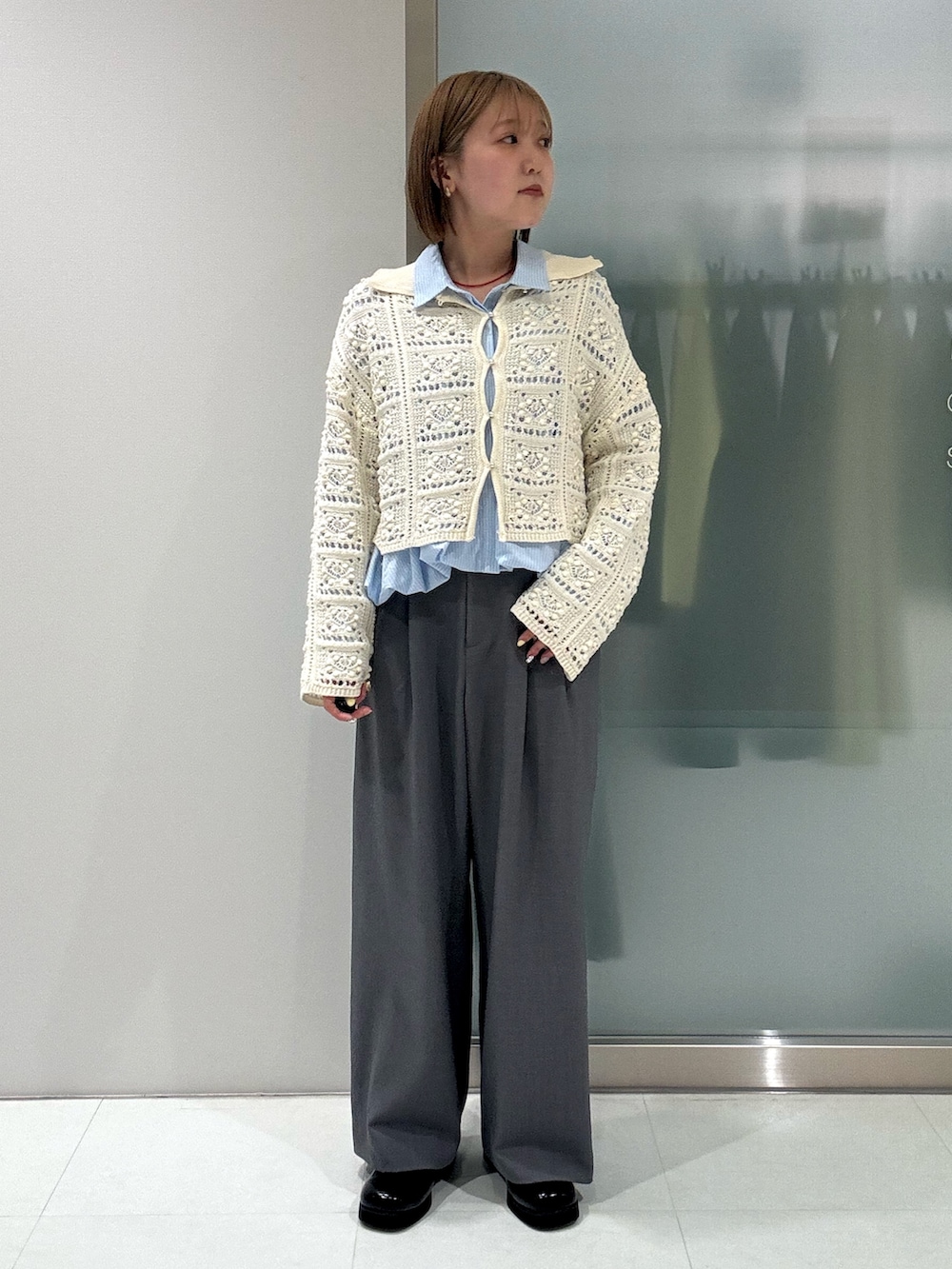 ホワイト系のカーディガン/ボレロ、ブルー系のシャツ/ブラウス、グレー系のスラックスを着用したレディースの春コーディネートの2枚目の写真