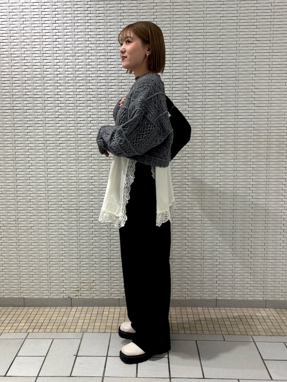 ホワイト系のキャミソール、ブラック系のその他パンツ、ブラック系のショルダーバッグを着用したレディースの冬コーディネートの2枚目の写真