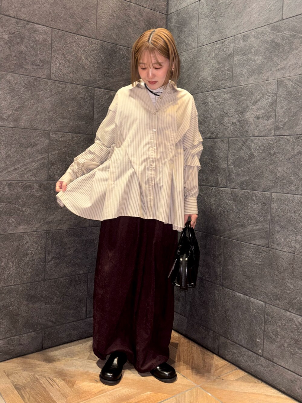 ホワイト系のTシャツ/カットソー、ベージュ系のシャツ/ブラウス、レッド系のその他パンツを着用したレディースの冬コーディネートの3枚目の写真