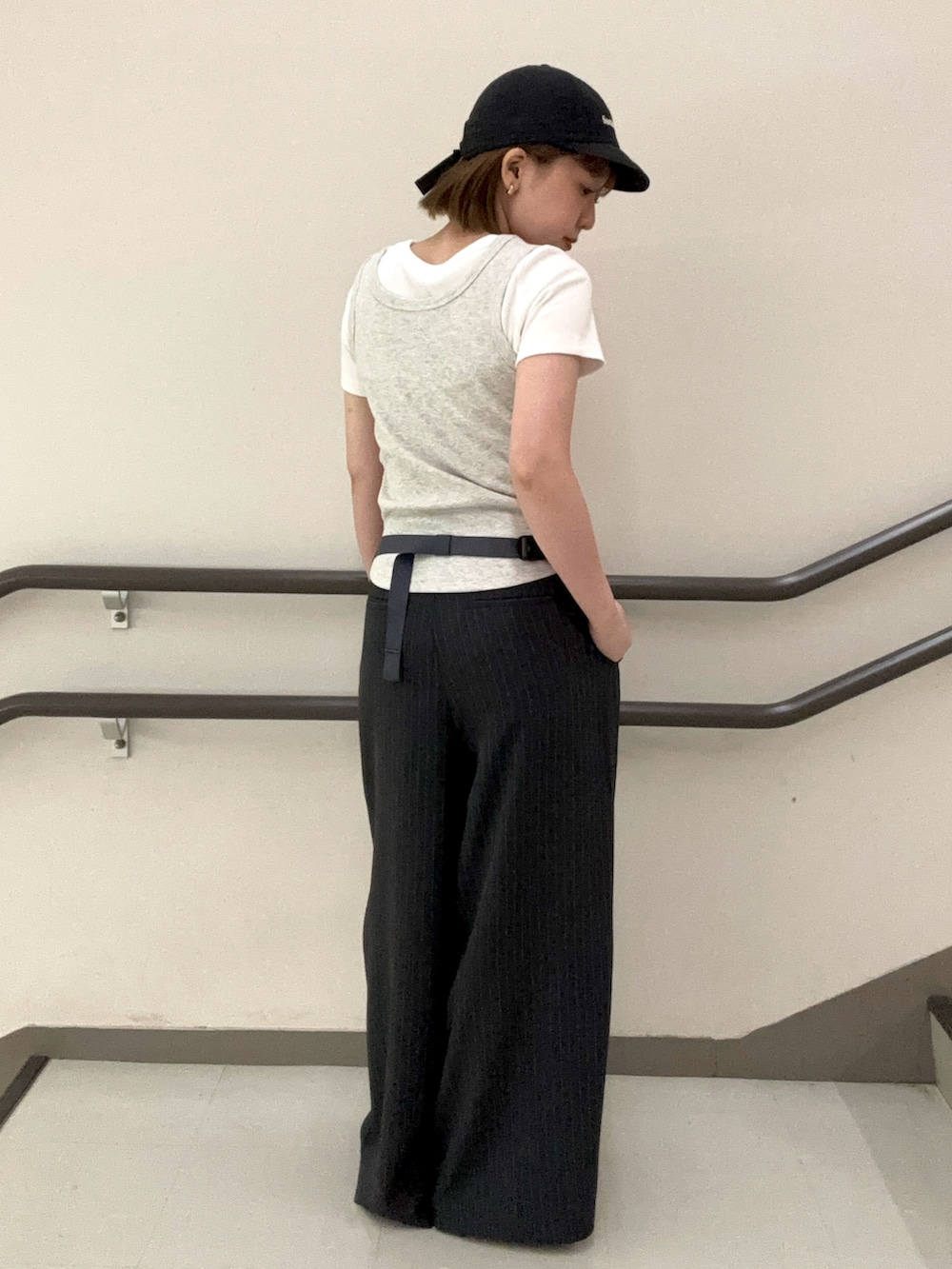 グレー系のタンクトップ、ホワイト系のTシャツ/カットソー、グレー系のスラックスを着用したレディースの夏コーディネートの5枚目の写真