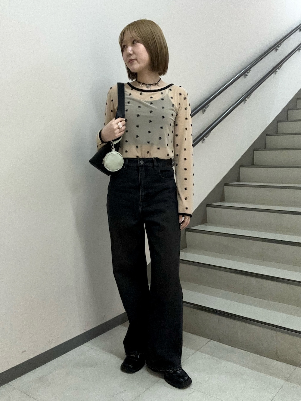 ベージュ系のTシャツ/カットソー、ブラック系のキャミソール、ブラック系のハンドバッグを着用したレディースの春コーディネートの3枚目の写真