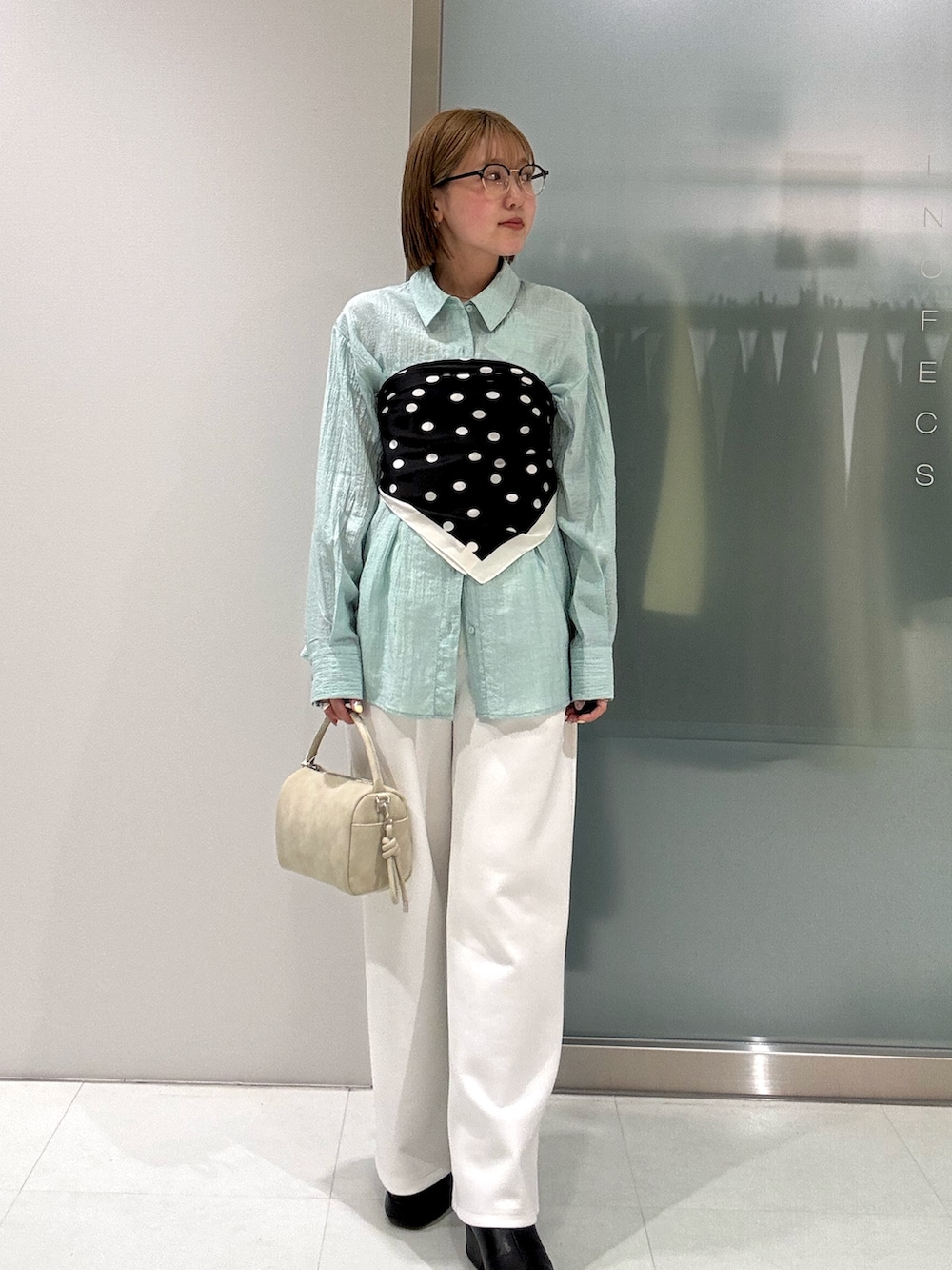 ベージュ系のハンドバッグ、ホワイト系のその他パンツ、グリーン系のシャツ/ブラウスを着用したレディースの春コーディネートの3枚目の写真