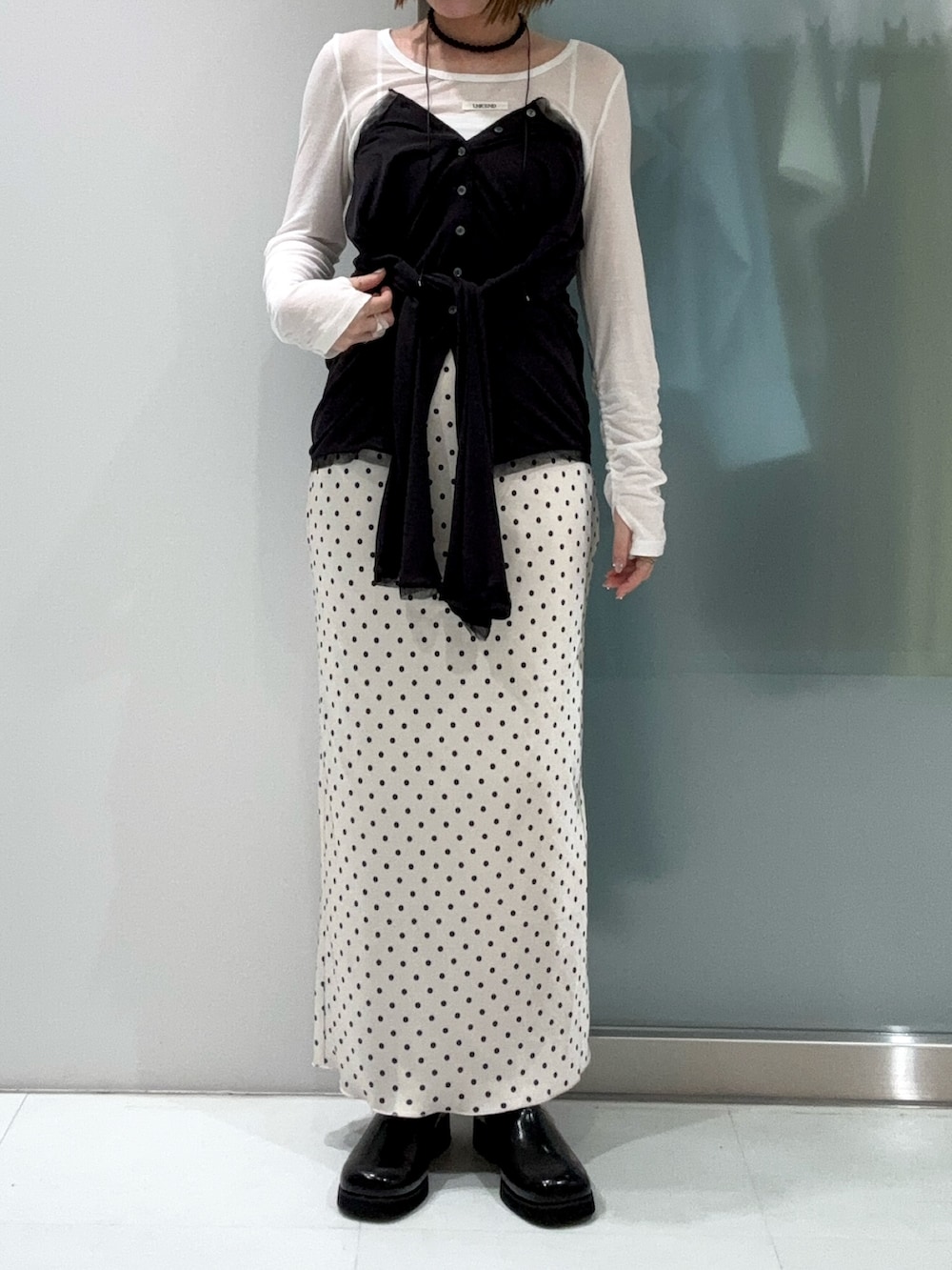 ホワイト系のTシャツ/カットソー、グレー系のカーディガン/ボレロ、ブラック系のサンダルを着用したレディースの春コーディネートの5枚目の写真