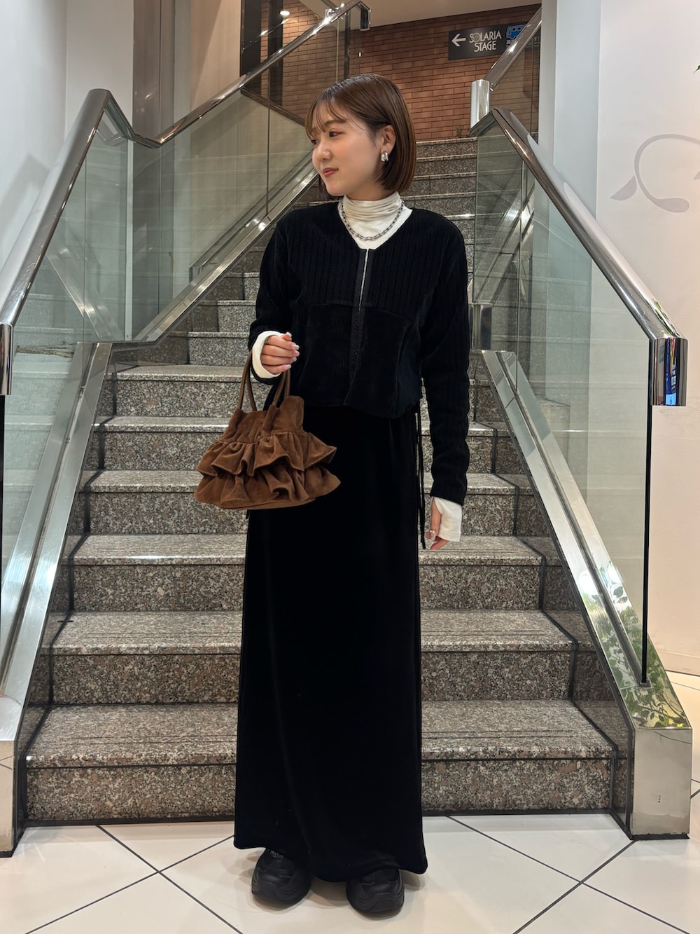 ホワイト系のTシャツ/カットソー、ブラック系のカーディガン/ボレロ、ブラック系のスカートを着用したレディースの冬コーディネートの2枚目の写真