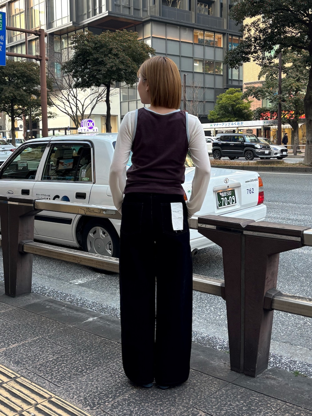 ホワイト系のTシャツ/カットソー、ブラック系のデニムパンツ、ブルー系のサンダルを着用したレディースの冬コーディネートの4枚目の写真