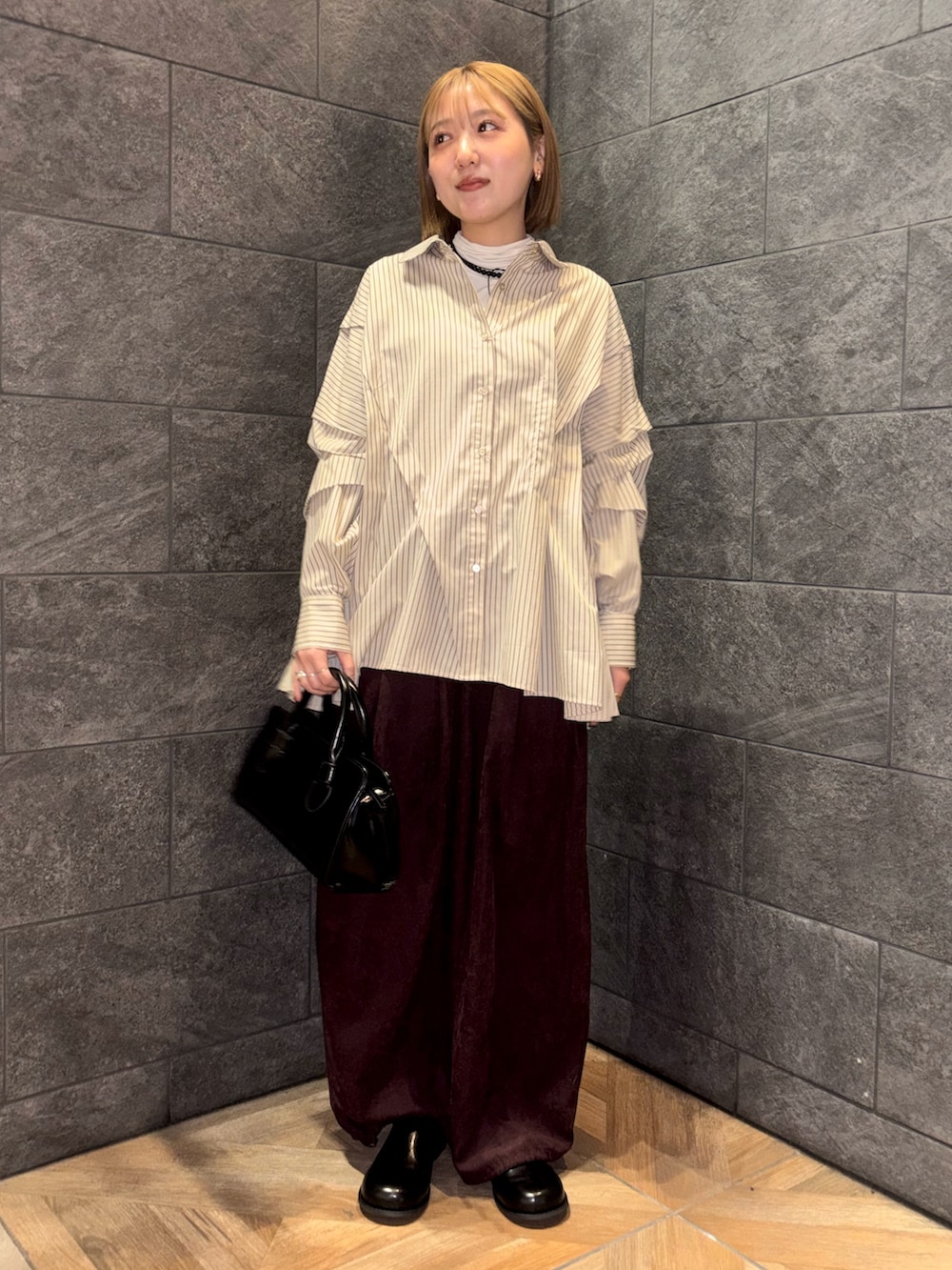 ホワイト系のTシャツ/カットソー、ベージュ系のシャツ/ブラウス、レッド系のその他パンツを着用したレディースの冬コーディネートの4枚目の写真