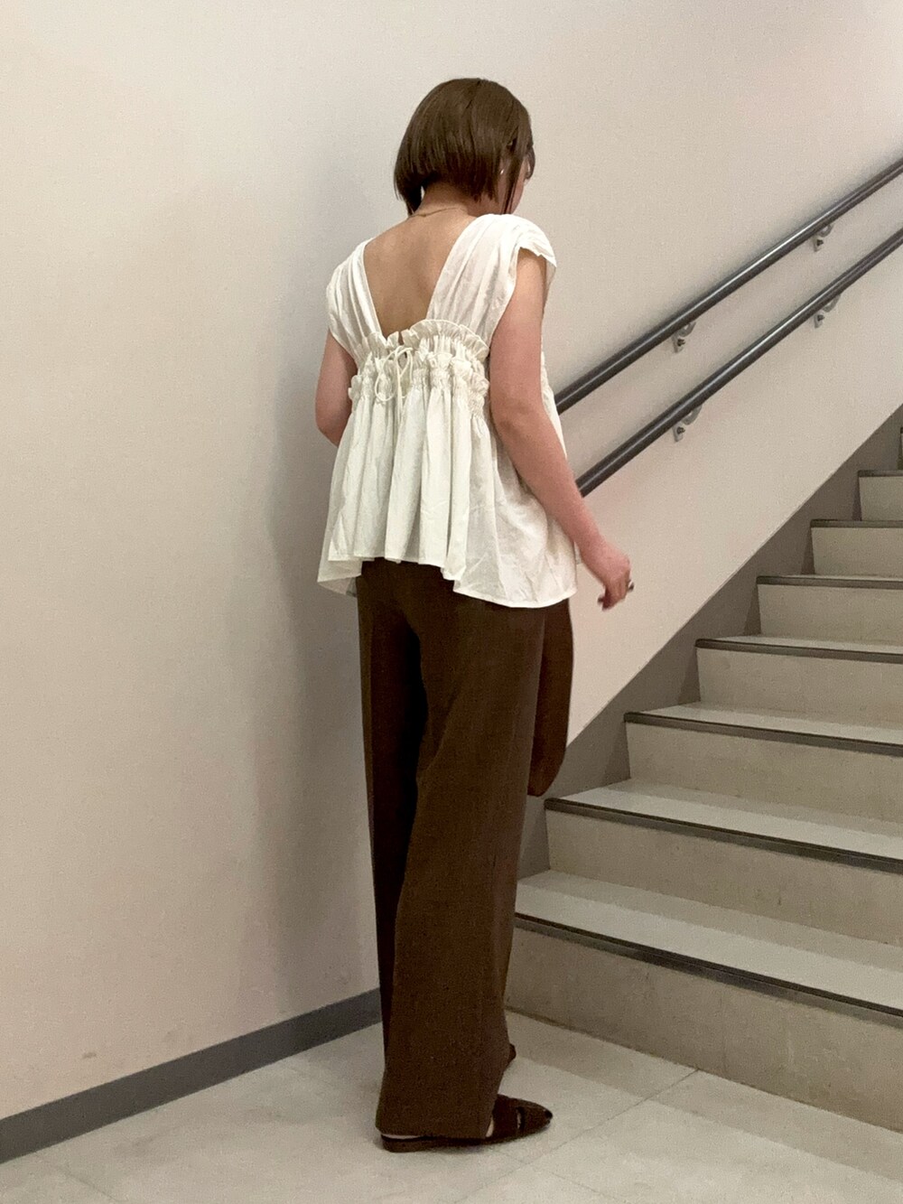 ブラウン系のその他パンツ、ブラウン系のサンダル、ホワイト系のシャツ/ブラウスを着用したレディースの夏コーディネートの4枚目の写真