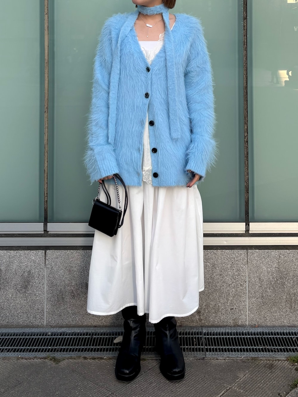 ブルー系のカーディガン/ボレロ、ホワイト系のキャミソール、ホワイト系のスカートを着用したレディースの冬コーディネートの3枚目の写真