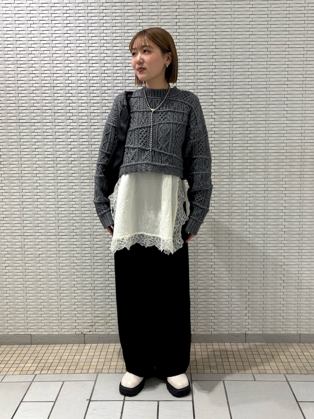 ホワイト系のキャミソール、ブラック系のその他パンツ、ブラック系のショルダーバッグを着用したレディースの冬コーディネートの3枚目の写真