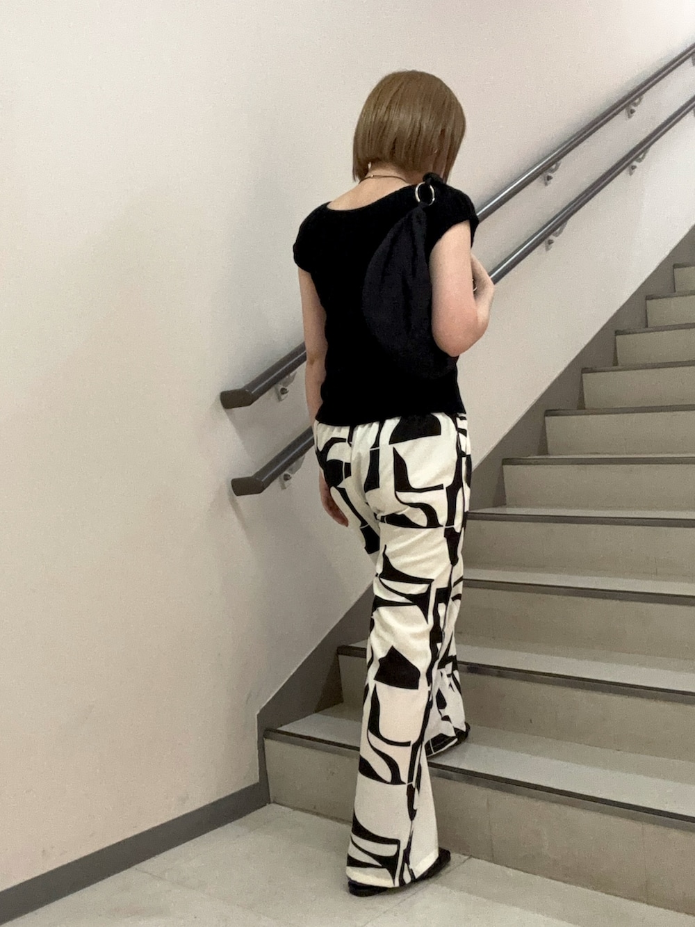 ブラック系のその他パンツ、ブラック系のサンダル、ブラック系のハンドバッグを着用したレディースの春コーディネートの5枚目の写真