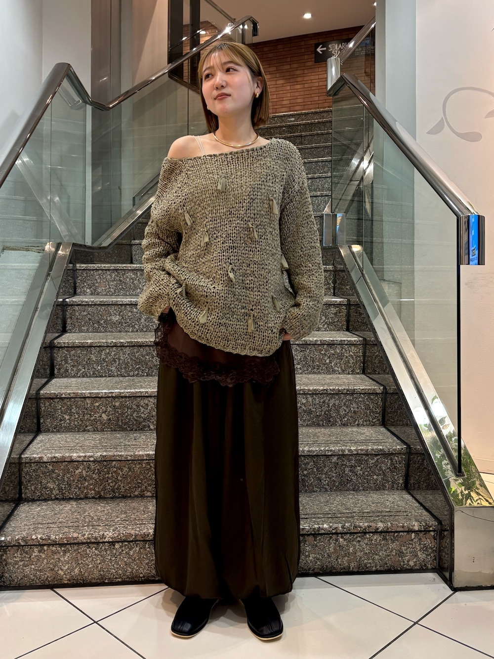 ホワイト系のキャミソール、グリーン系のニット/セーター、ブラウン系のキャミソールを着用したレディースの冬コーディネートの2枚目の写真