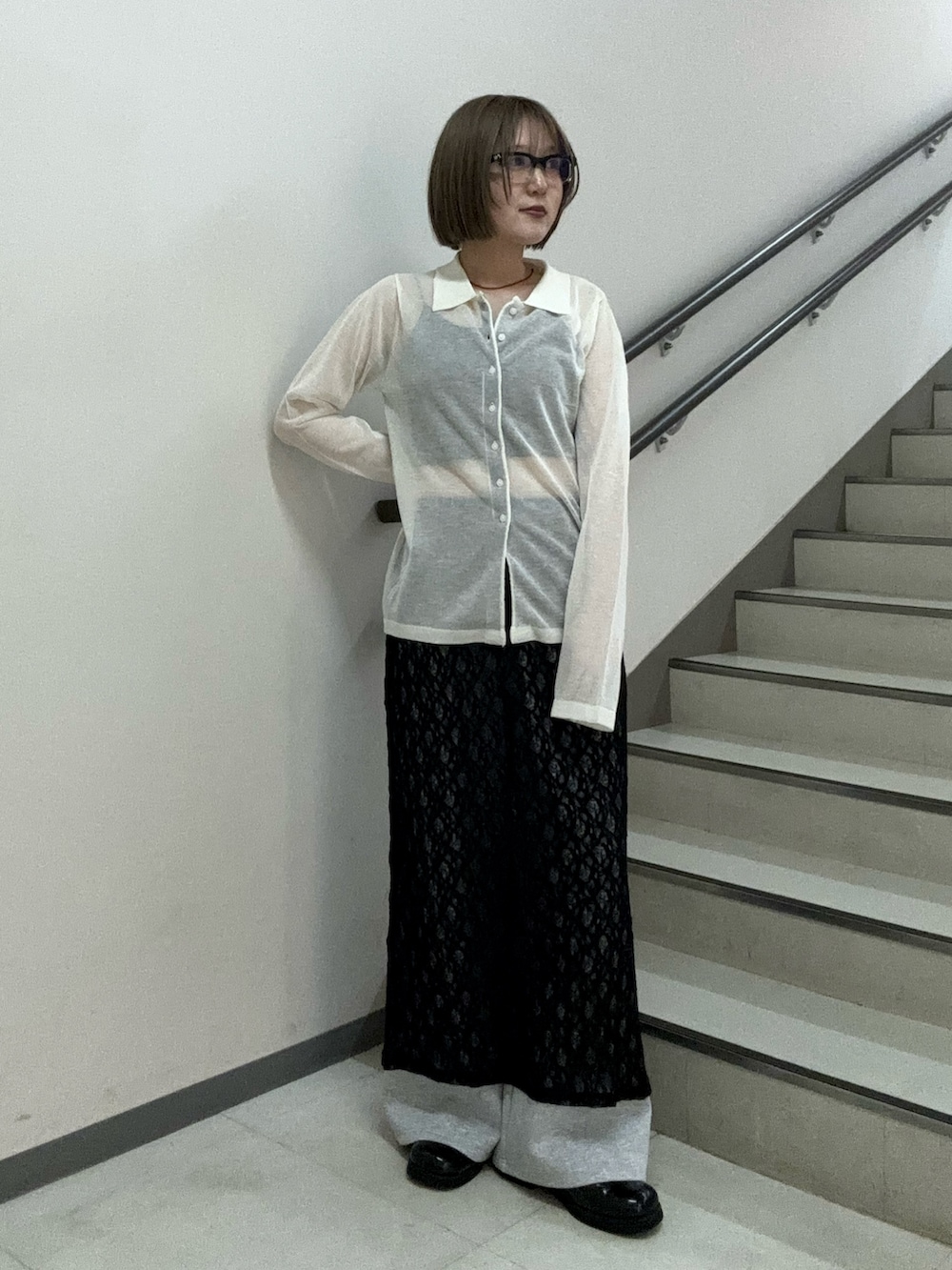 ホワイト系のニット/セーター、ブラック系のキャミソール、ブラック系のスカートを着用したレディースの春コーディネートの2枚目の写真