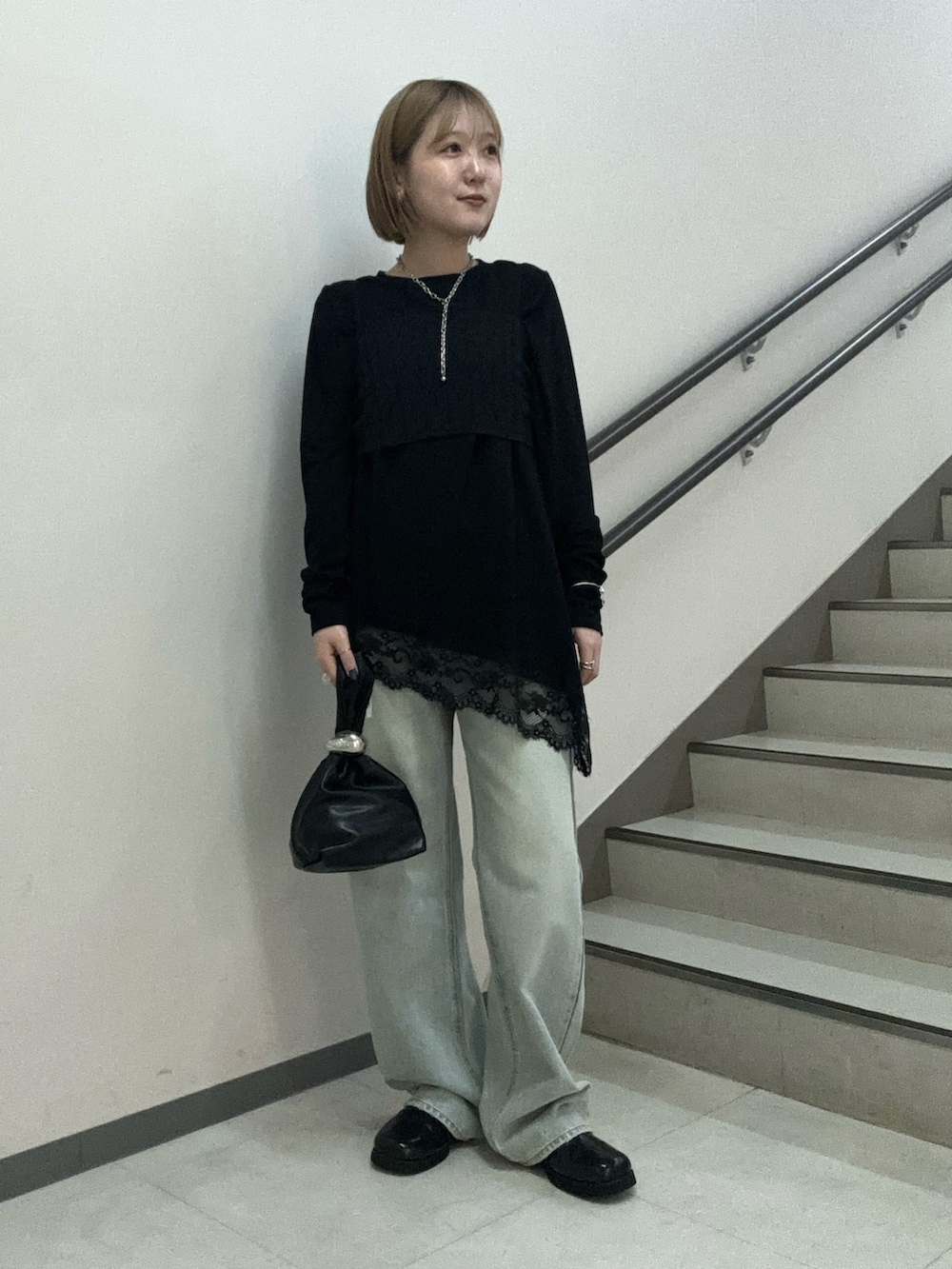 ブラック系のTシャツ/カットソー、ブラック系のハンドバッグ、ブラック系のサンダルを着用したレディースの春コーディネートの2枚目の写真