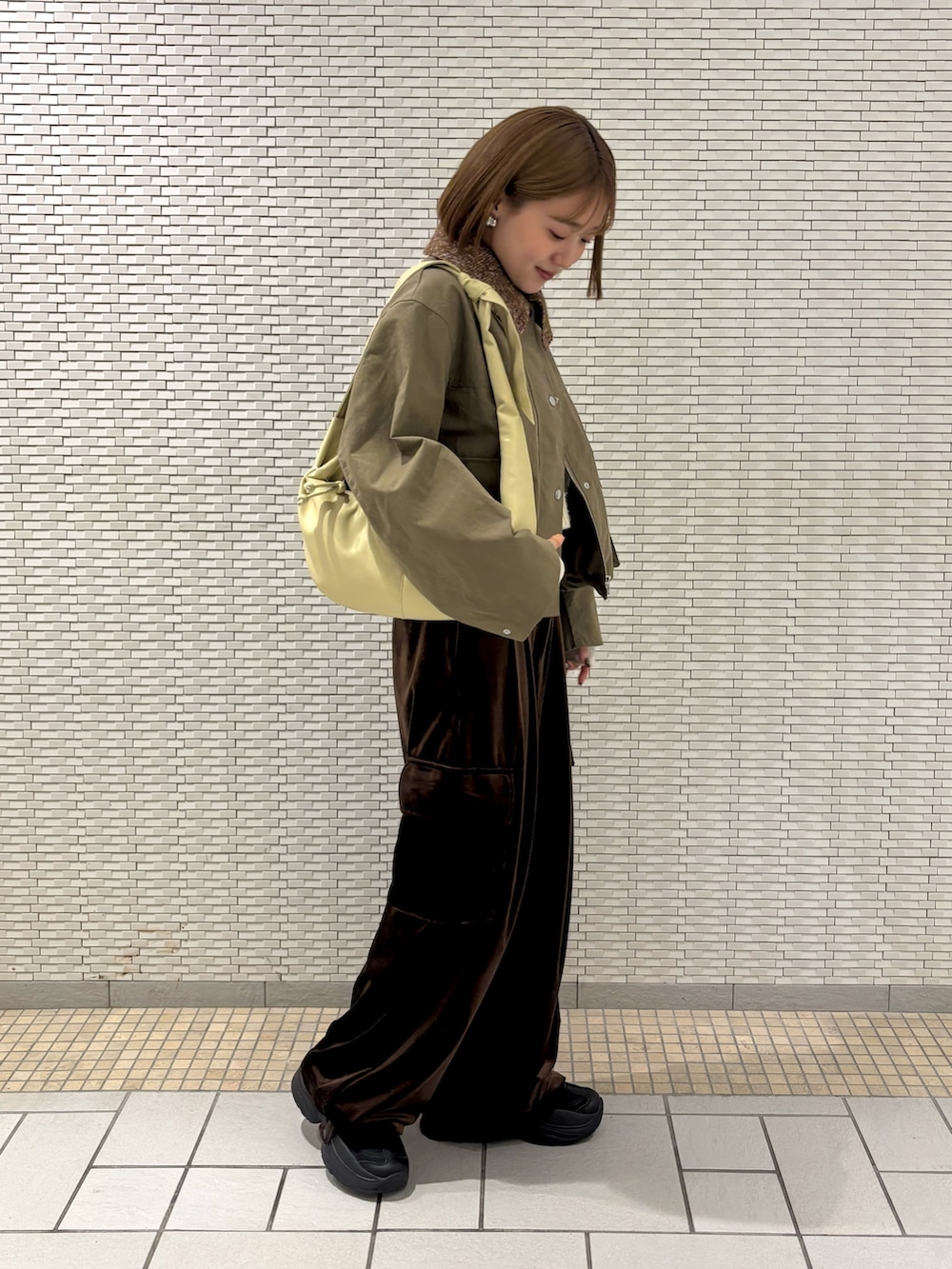 グリーン系のブルゾン、ブラウン系のその他パンツ、ホワイト系のTシャツ/カットソーを着用したレディースの冬コーディネートの4枚目の写真