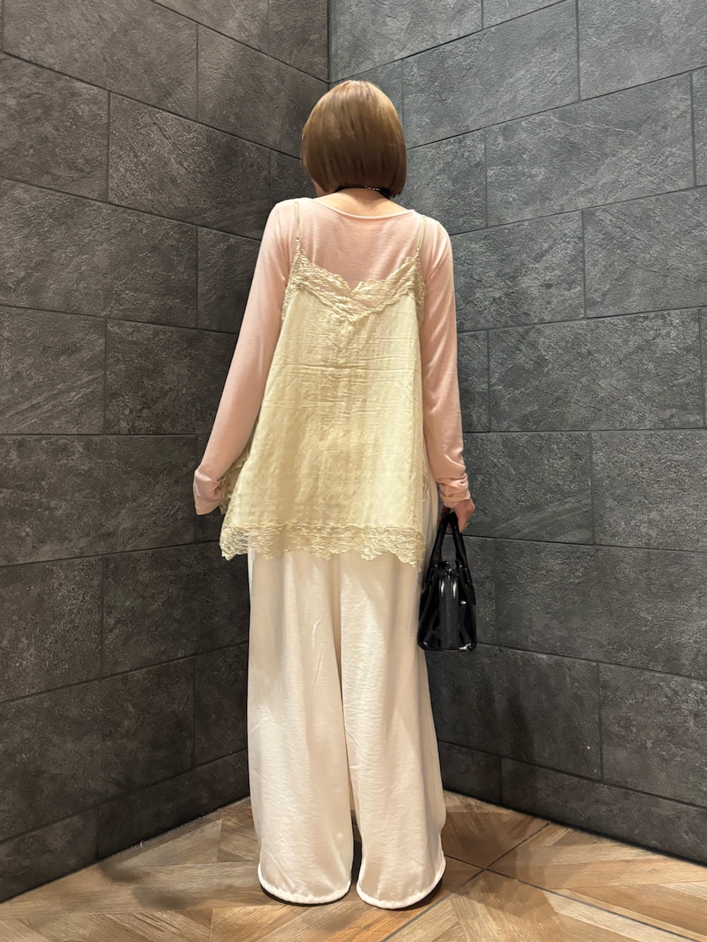 ピンク系のTシャツ/カットソー、ベージュ系のキャミソール、ホワイト系のその他パンツを着用したレディースの冬コーディネートの4枚目の写真