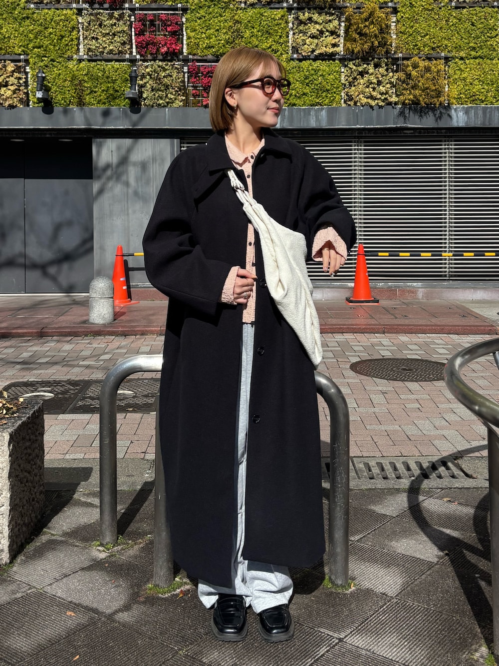 ピンク系のシャツ/ブラウス、グレー系のその他パンツ、ブラック系のステンカラーコートを着用したレディースの冬コーディネートの5枚目の写真