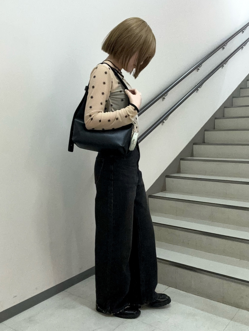 ベージュ系のTシャツ/カットソー、ブラック系のキャミソール、ブラック系のハンドバッグを着用したレディースの春コーディネートの6枚目の写真