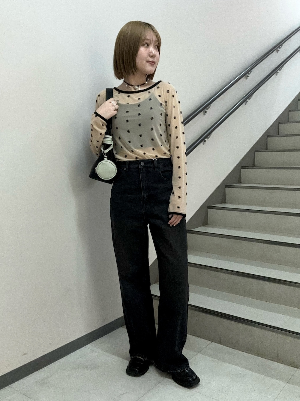 ベージュ系のTシャツ/カットソー、ブラック系のキャミソール、ブラック系のハンドバッグを着用したレディースの春コーディネートの2枚目の写真