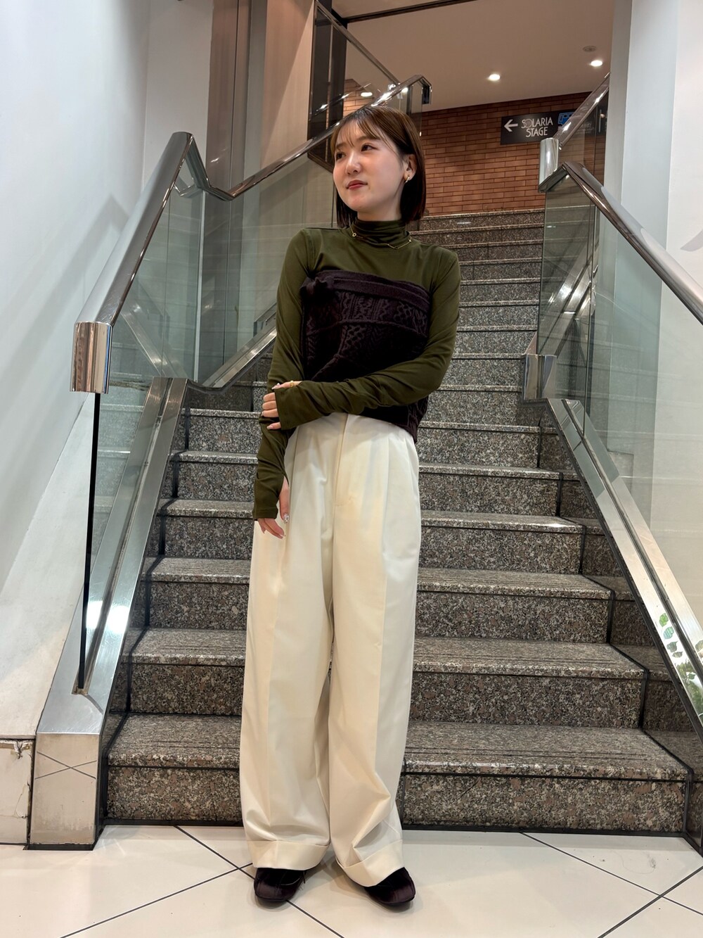 グリーン系のTシャツ/カットソー、ブラウン系のスカート、ホワイト系のその他パンツを着用したレディースの冬コーディネートの2枚目の写真