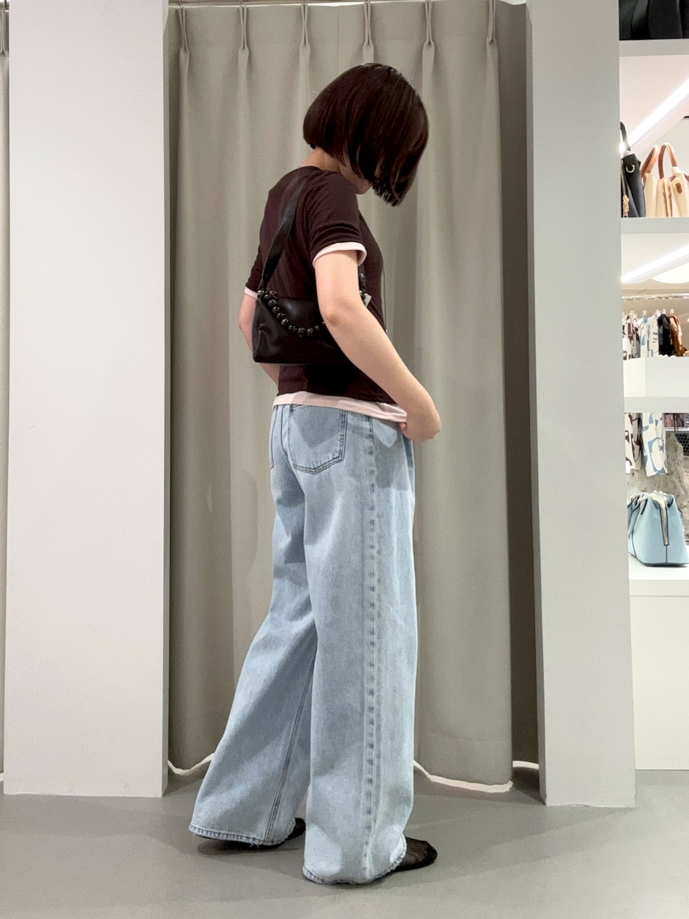 ブルー系のデニムパンツ、ブラウン系のショルダーバッグ、ブラック系のパンプスを着用したレディースの夏コーディネートの3枚目の写真