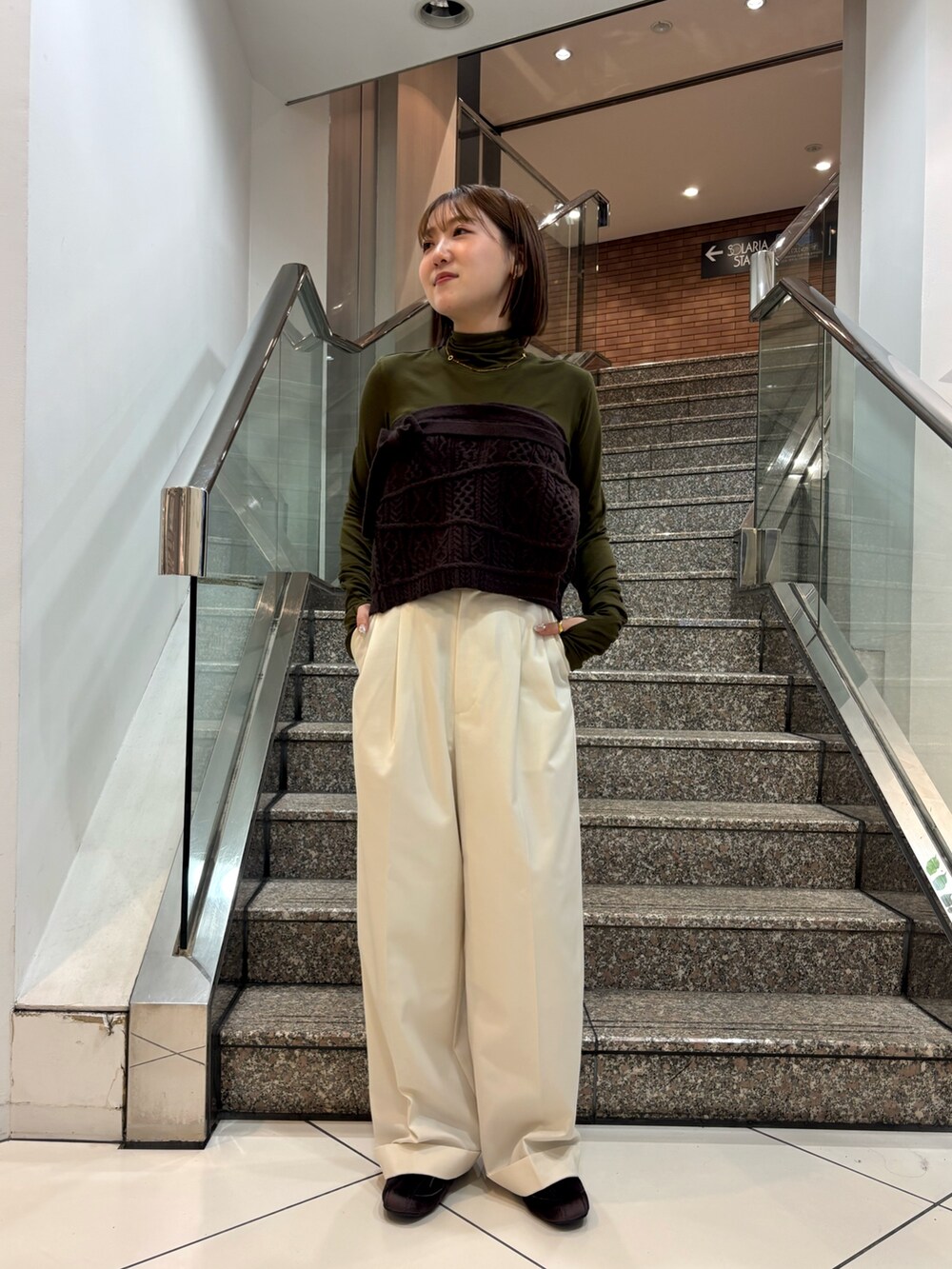 グリーン系のTシャツ/カットソー、ブラウン系のスカート、ホワイト系のその他パンツを着用したレディースの冬コーディネートの5枚目の写真