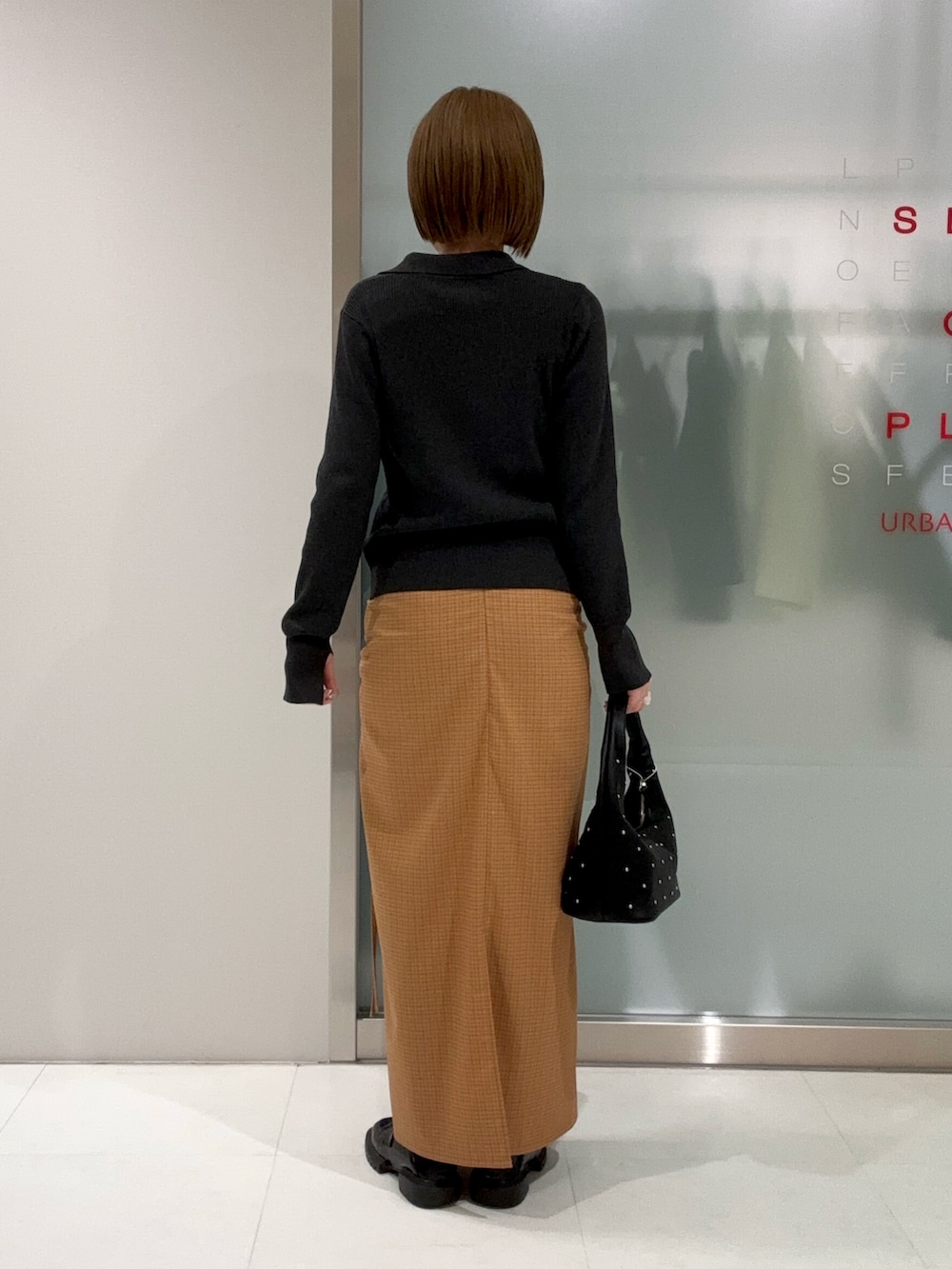 グレー系のカーディガン/ボレロ、ブラック系のハンドバッグ、イエロー系のスカートを着用したレディースの春コーディネートの6枚目の写真