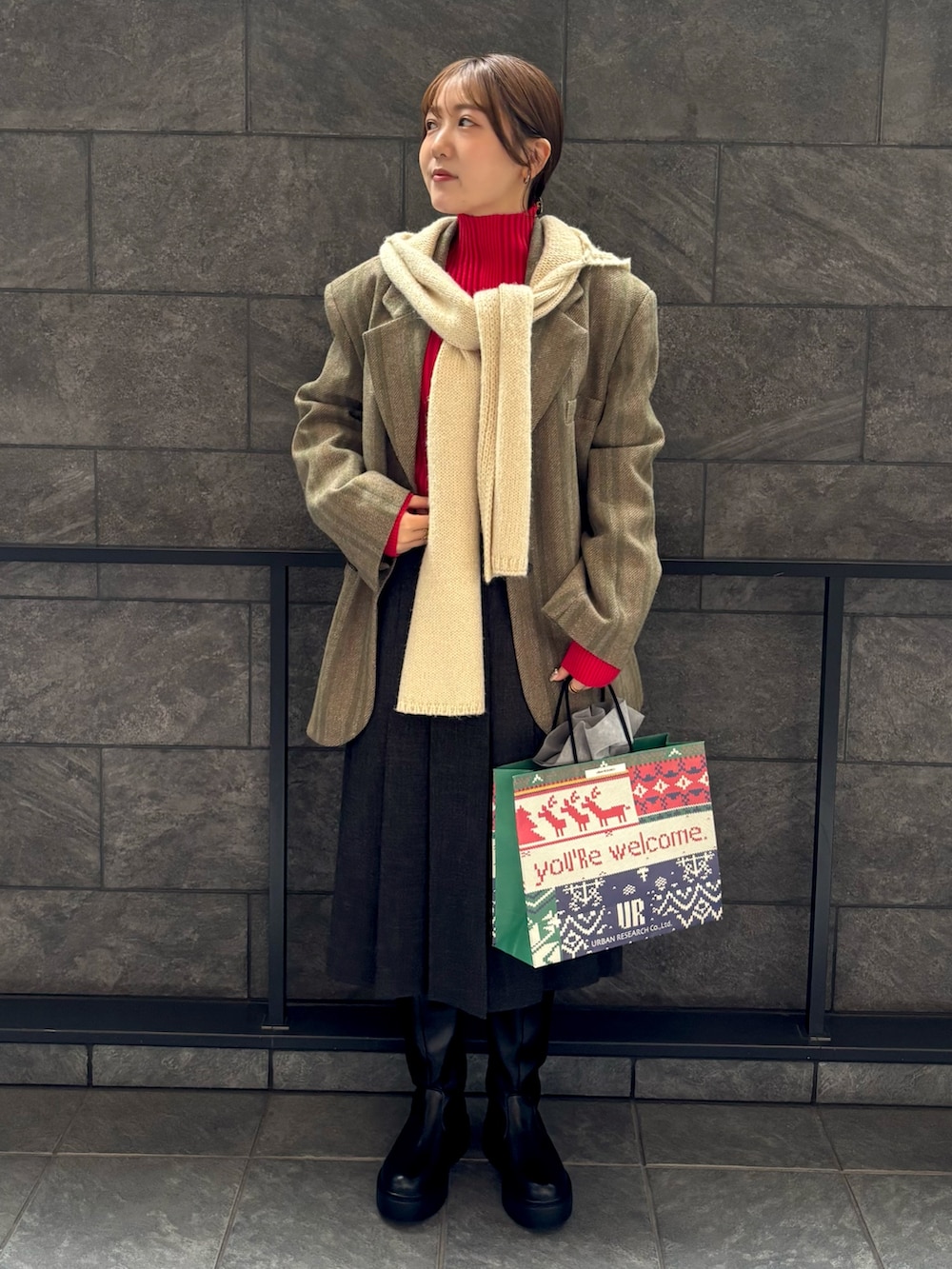 レッド系のニット/セーター、グレー系のスカート、グリーン系のその他アウターを着用したレディースの秋コーディネートの2枚目の写真