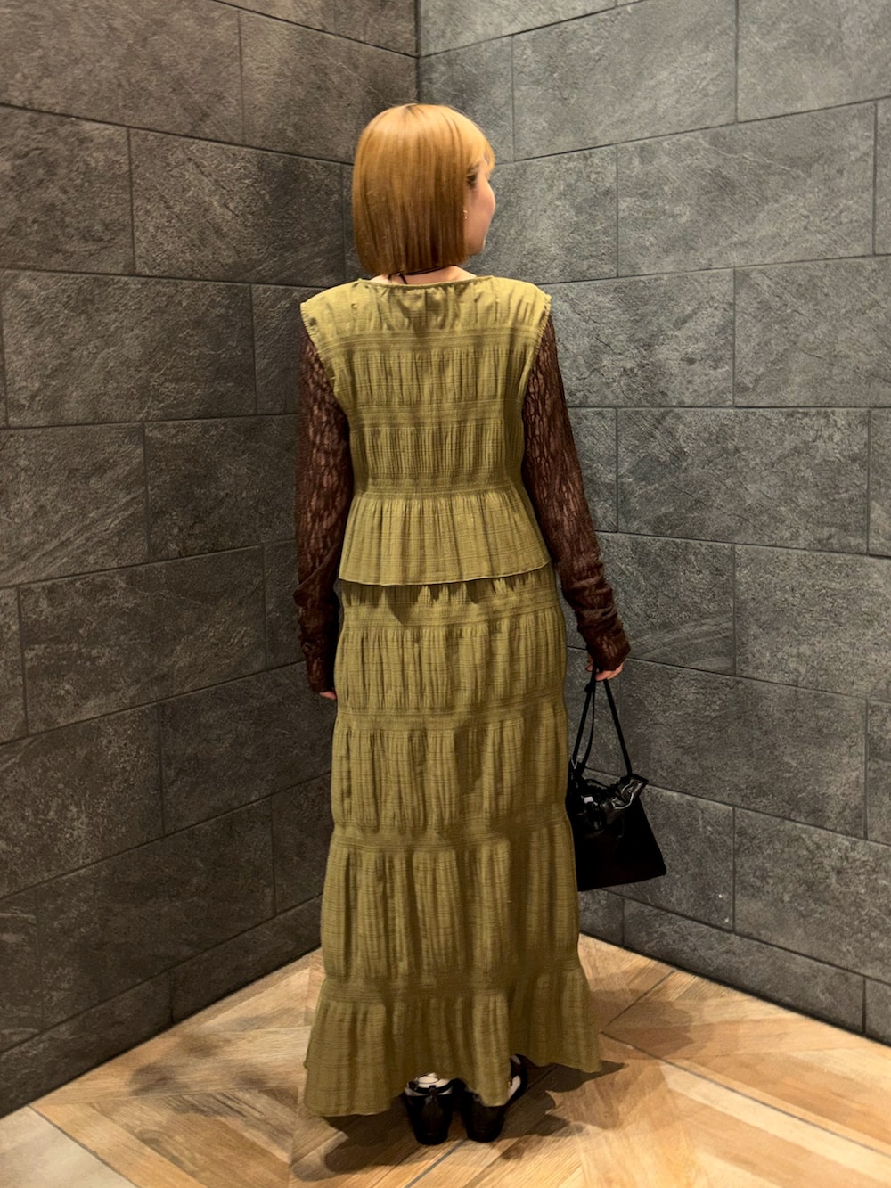 ブラウン系のTシャツ/カットソー、ブラック系のローファー、ブラック系のショルダーバッグを着用したレディースの冬コーディネートの3枚目の写真