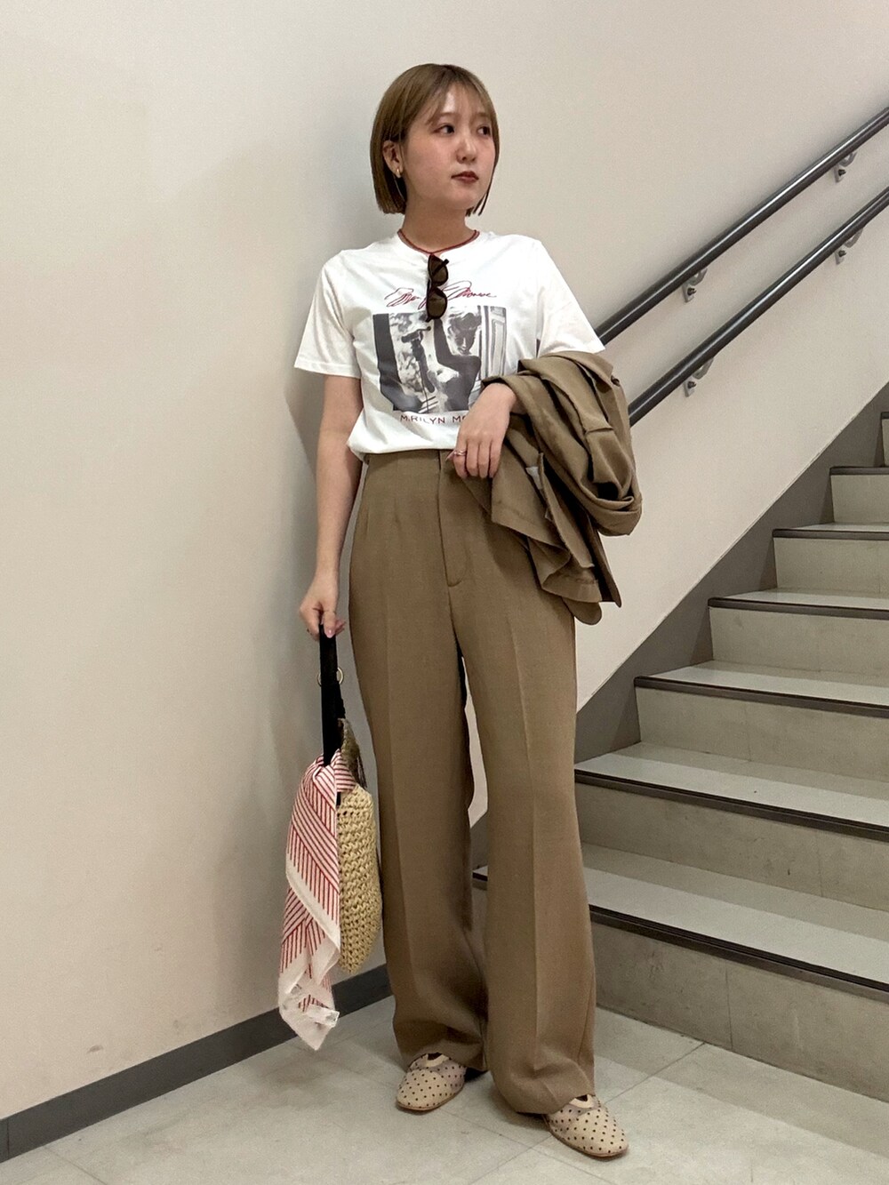 ベージュ系のその他パンツ、ベージュ系のトートバッグ、その他のTシャツ/カットソーを着用したレディースの春コーディネートの2枚目の写真