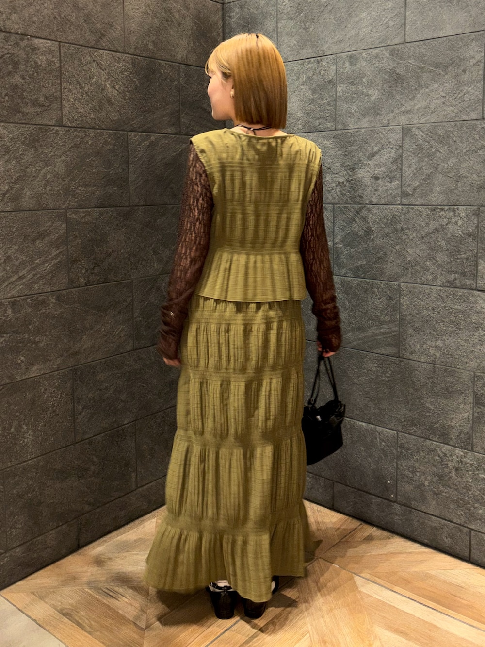 ブラウン系のTシャツ/カットソー、ブラック系のローファー、ブラック系のショルダーバッグを着用したレディースの冬コーディネートの4枚目の写真