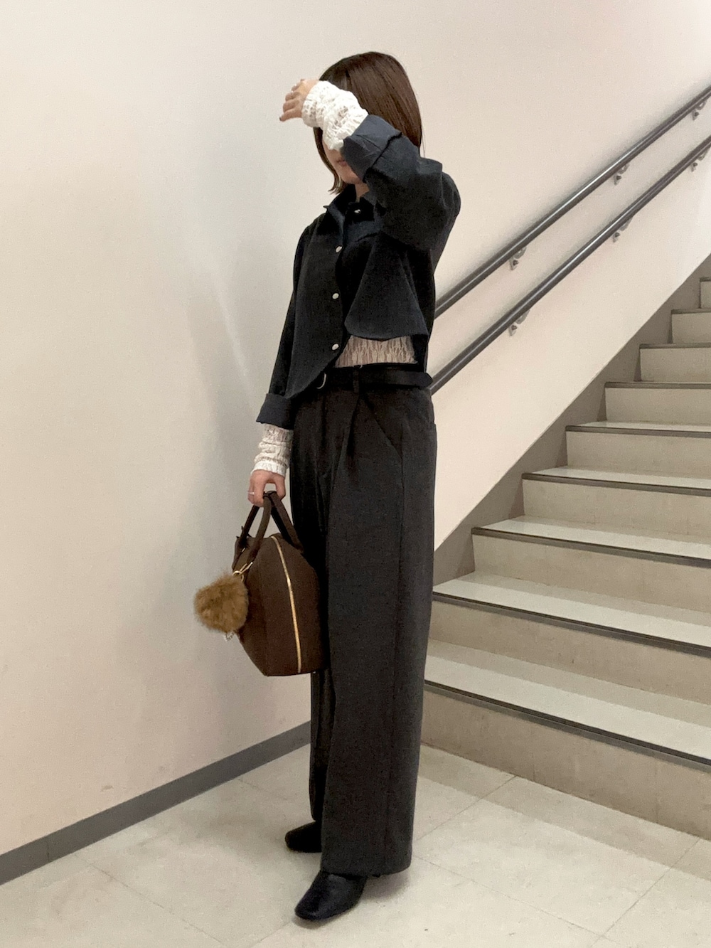 グレー系のその他パンツ、ブラウン系のボストンバッグ、ブラック系のブーツを着用したレディースの秋コーディネートの2枚目の写真
