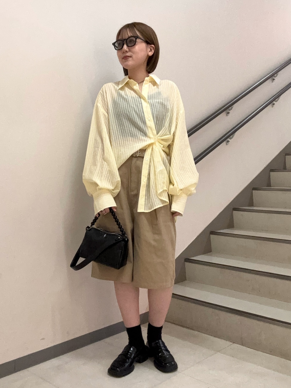ブラック系のショルダーバッグ、ベージュ系のその他パンツ、イエロー系のシャツ/ブラウスを着用したレディースの夏コーディネートの5枚目の写真