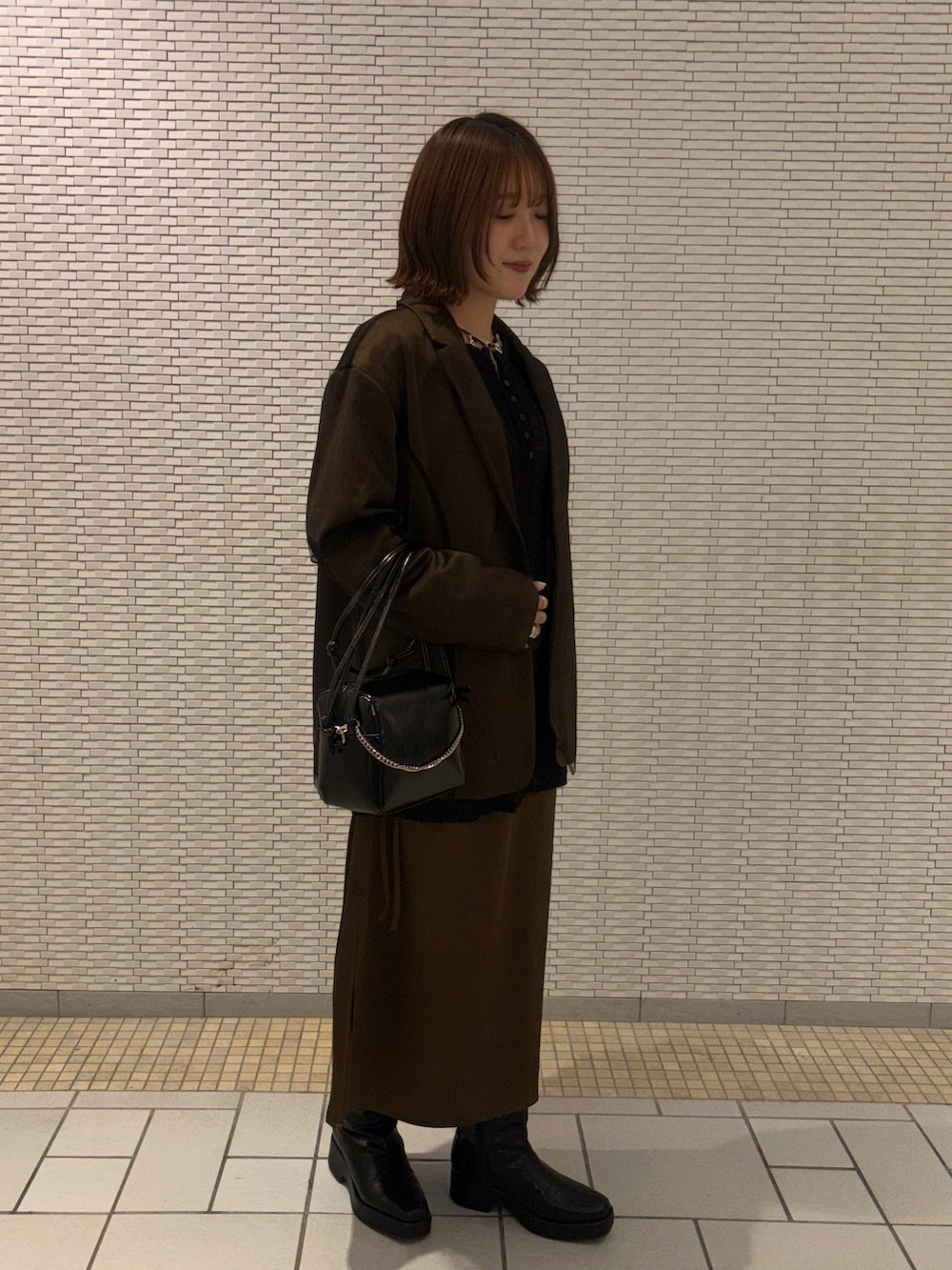 ブラウン系のその他アウター、ブラウン系のワンピース、ブラック系のTシャツ/カットソーを着用したレディースの冬コーディネートの4枚目の写真