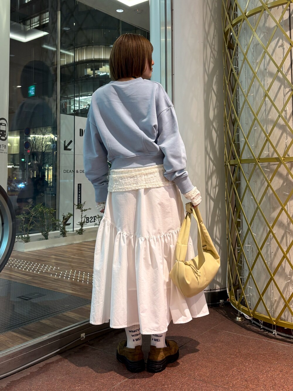 ブルー系のスウェット、ホワイト系のTシャツ/カットソー、ホワイト系のスカートを着用したレディースの冬コーディネートの3枚目の写真