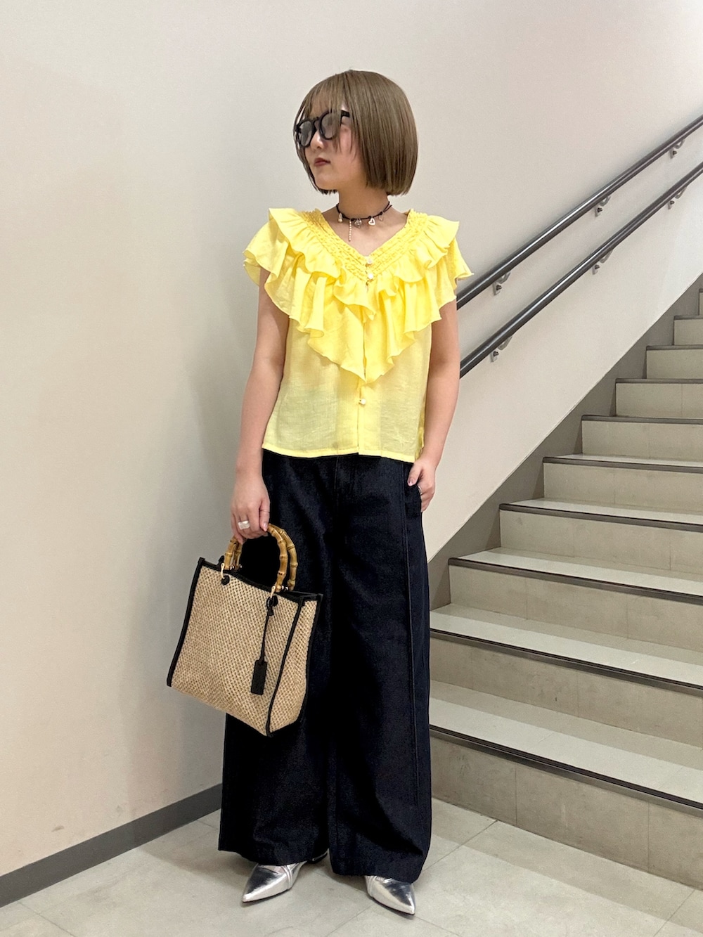 イエロー系のシャツ/ブラウス、シルバー系のパンプス、ブラック系のショルダーバッグを着用したレディースの春コーディネートの4枚目の写真