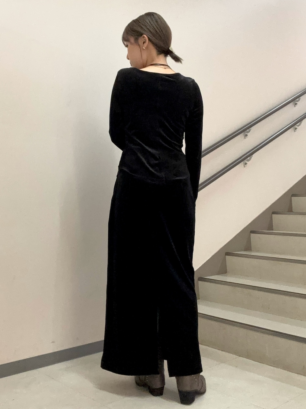 ブラック系のスカート、ブラック系のTシャツ/カットソー、ブラウン系のハンドバッグを着用したレディースの秋コーディネートの3枚目の写真