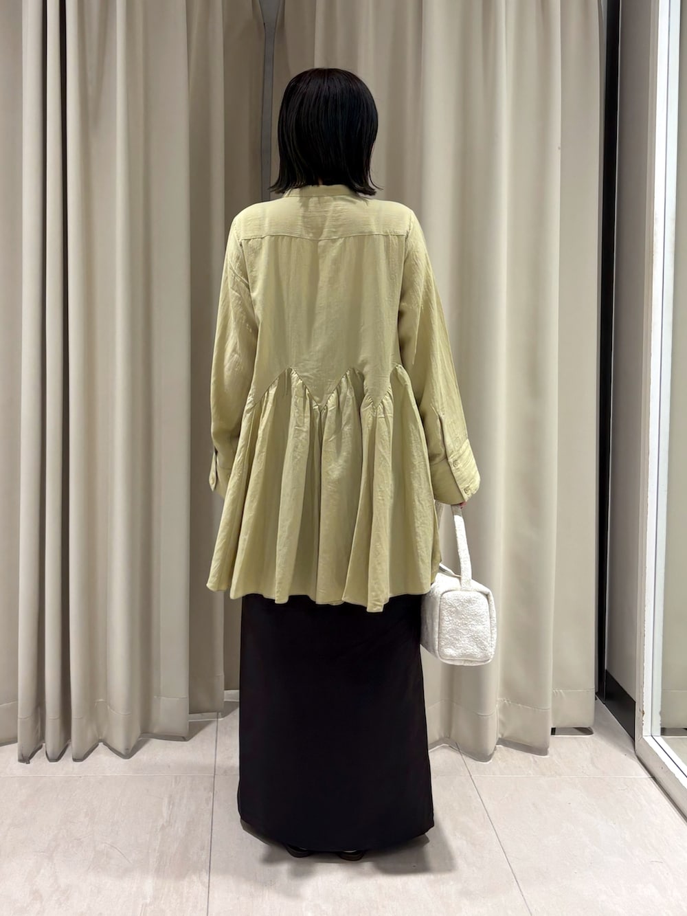 ブラウン系のTシャツ/カットソー、ブラウン系のスカート、ホワイト系のハンドバッグを着用したレディースの秋コーディネートの4枚目の写真