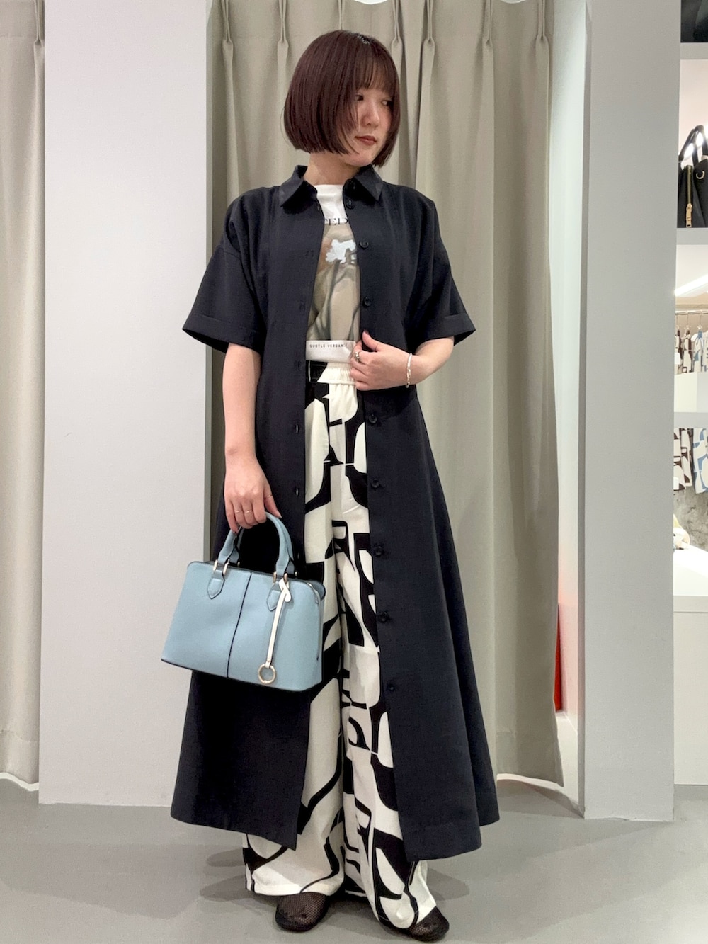 グレー系のワンピース、ブラック系のその他パンツ、ブルー系のハンドバッグを着用したレディースの夏コーディネートの2枚目の写真