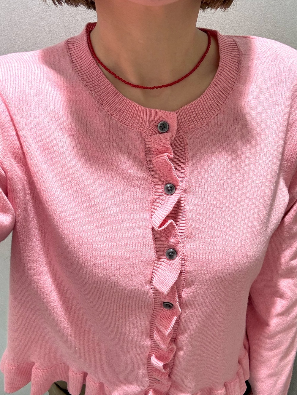 ベージュ系のその他パンツ、ピンク系のニット/セーター、レッド系のネックレスを着用したレディースの冬コーディネートの5枚目の写真