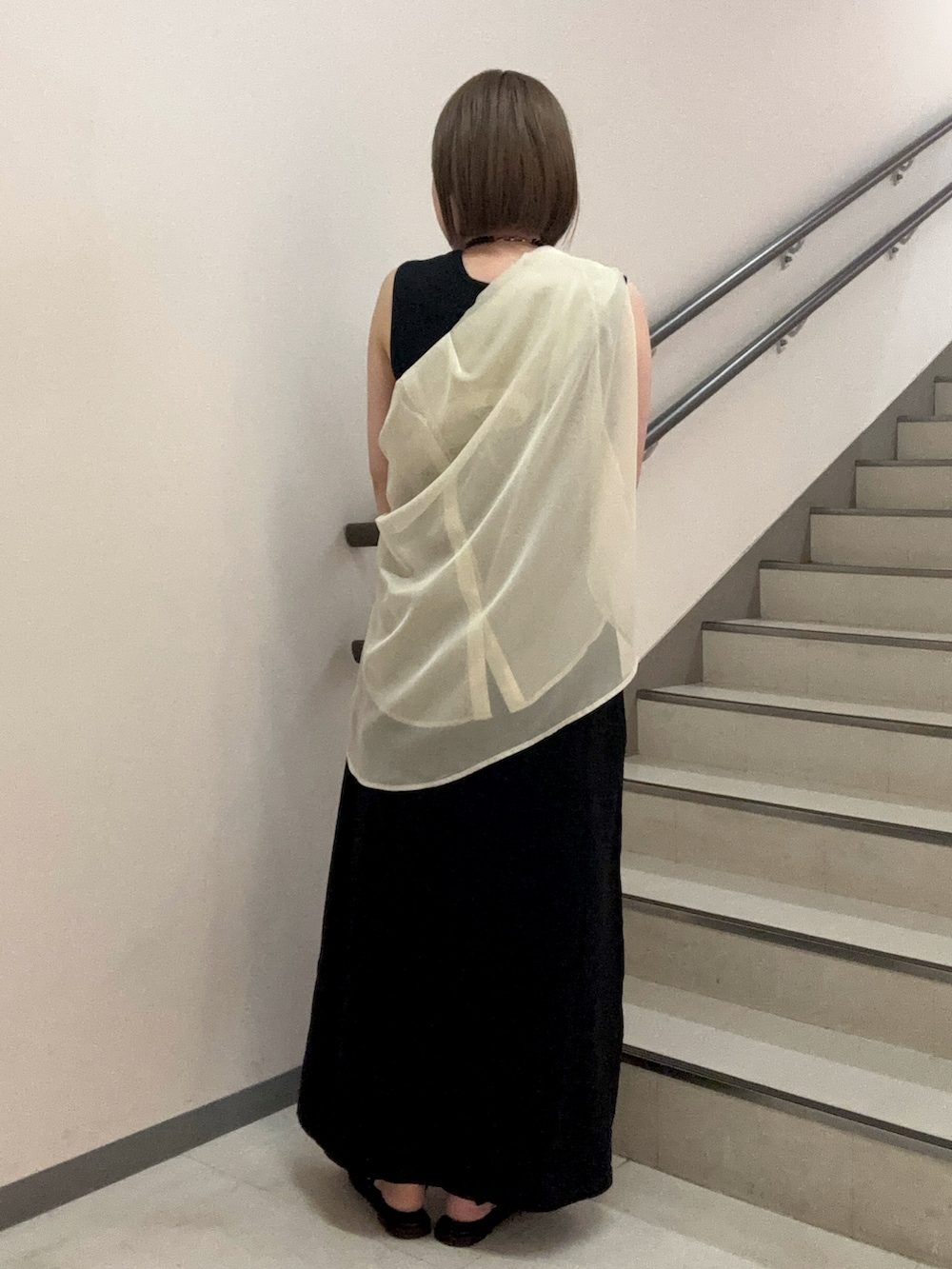ブラック系のワンピース、ホワイト系のシャツ/ブラウス、ベージュ系のハンドバッグを着用したレディースの春コーディネートの3枚目の写真