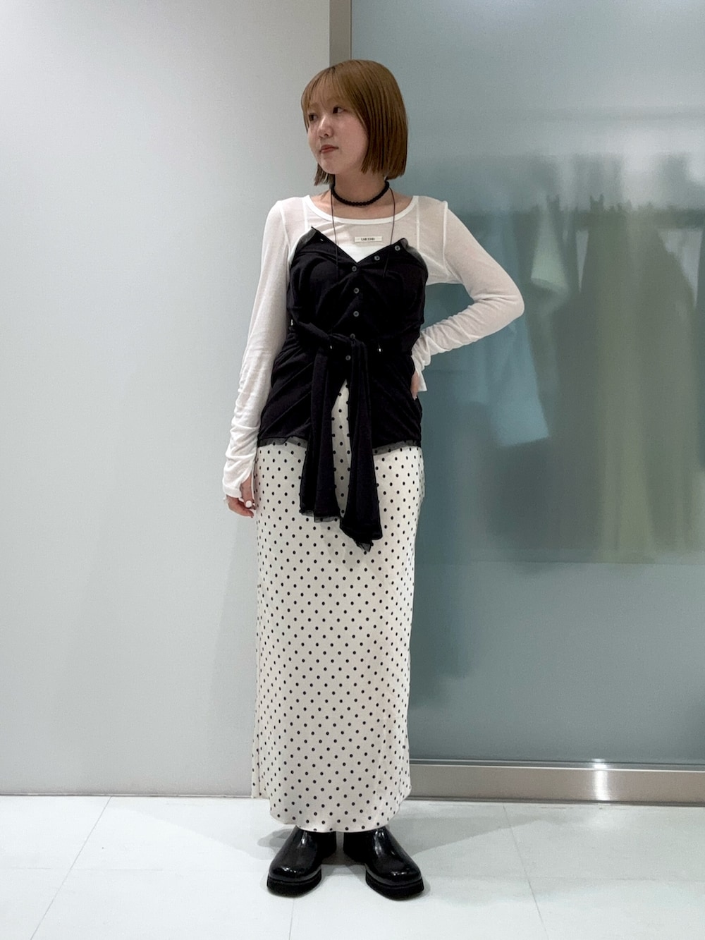 ホワイト系のTシャツ/カットソー、グレー系のカーディガン/ボレロ、ブラック系のサンダルを着用したレディースの春コーディネートの2枚目の写真