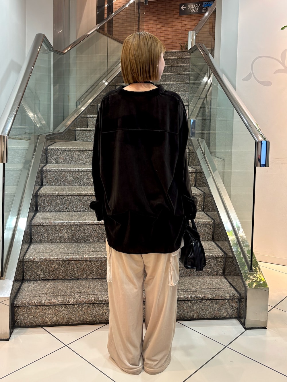 ブラック系のシャツ/ブラウス、ブラック系のボストンバッグ、ベージュ系のその他パンツを着用したレディースの冬コーディネートの3枚目の写真