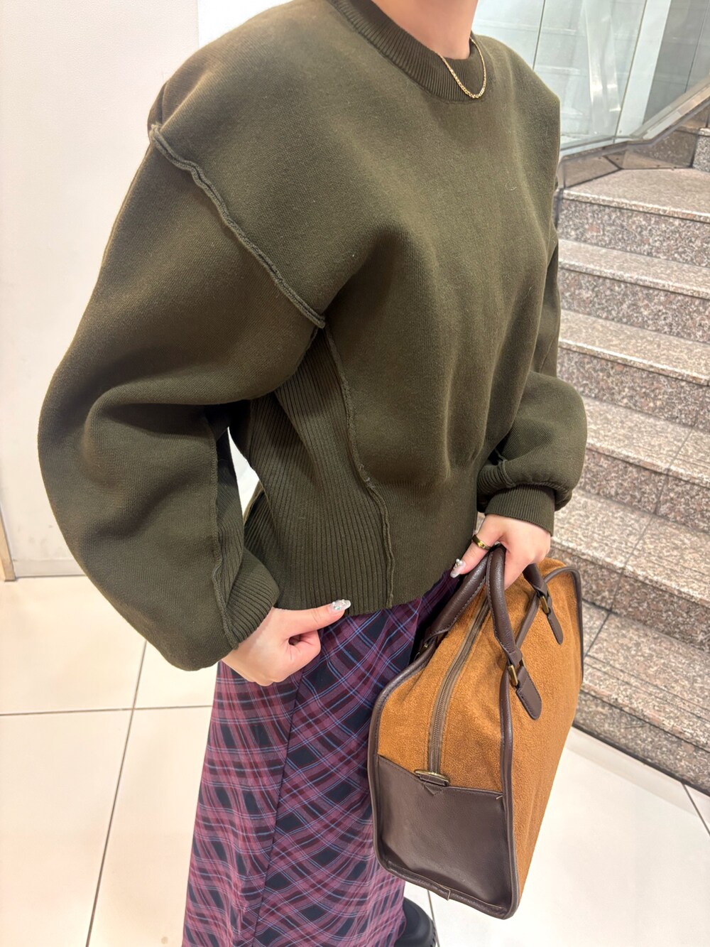 ブラック系のスニーカー、レッド系のスカート、イエロー系のボストンバッグを着用したレディースの冬コーディネートの5枚目の写真