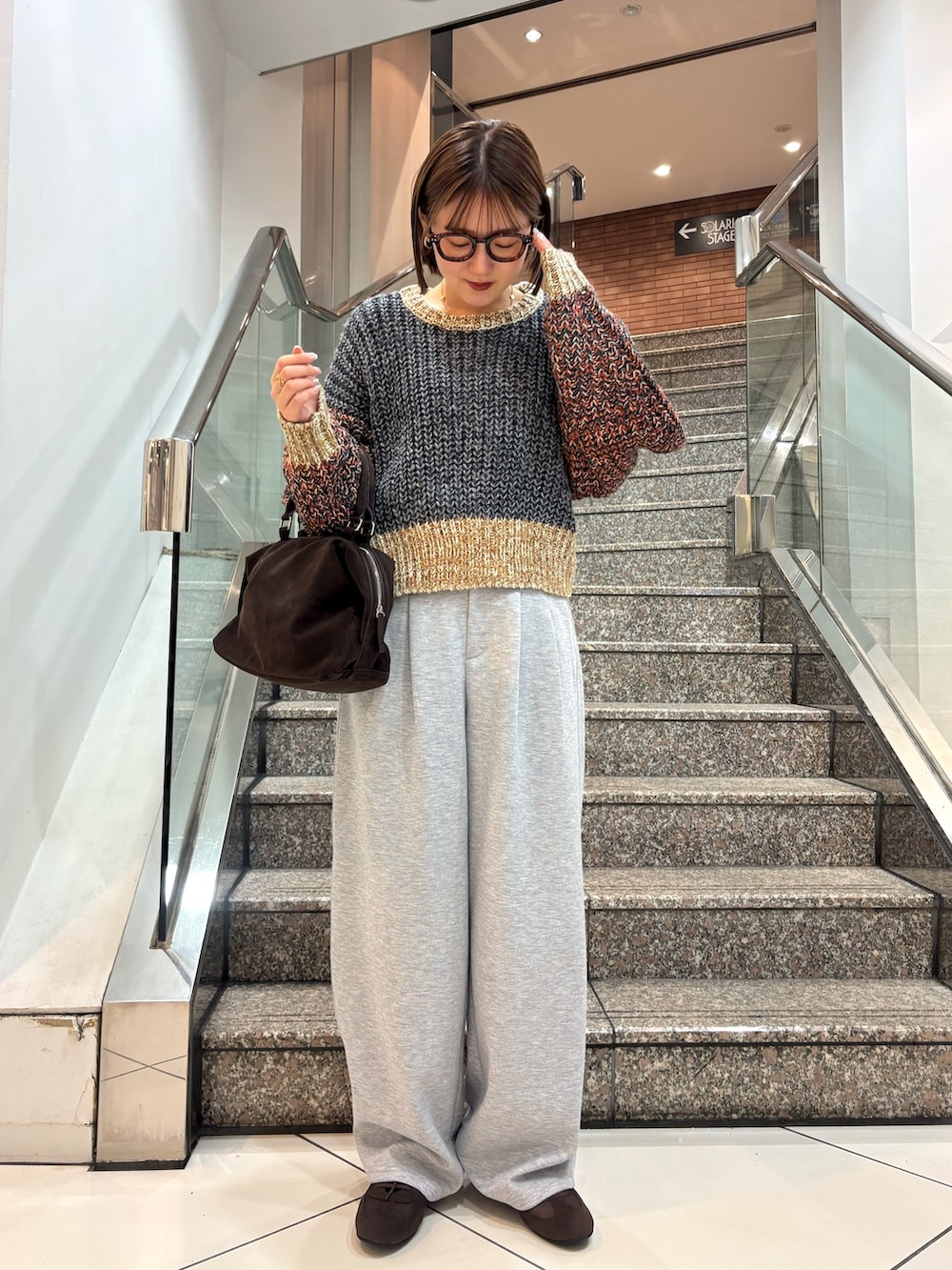 グレー系のニット/セーター、グレー系のその他パンツ、ブラウン系のスニーカーを着用したレディースの冬コーディネートの3枚目の写真