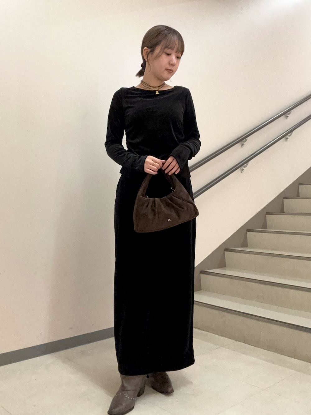 ブラック系のスカート、ブラック系のTシャツ/カットソー、ブラウン系のハンドバッグを着用したレディースの秋コーディネートの4枚目の写真