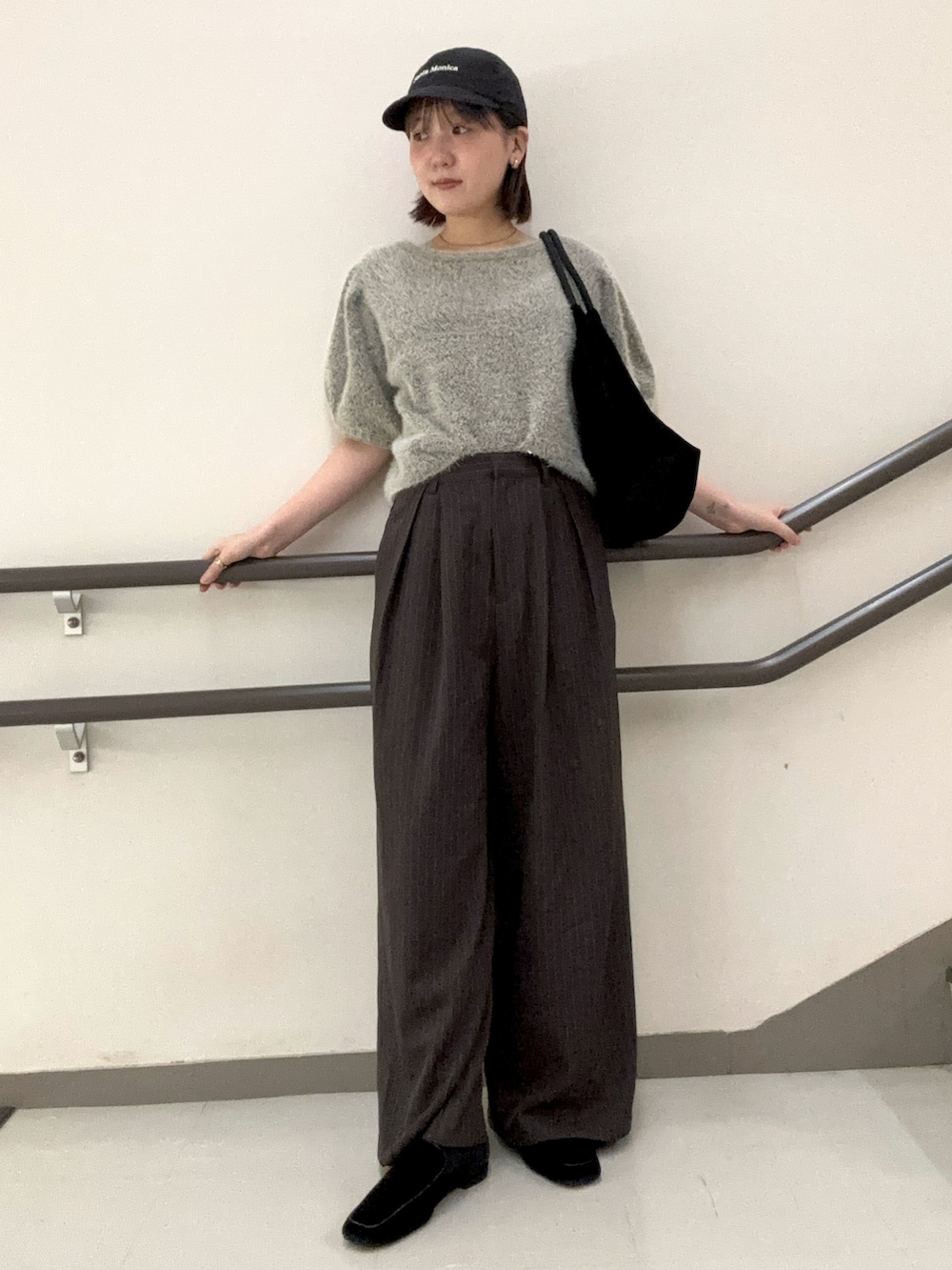 ブラウン系のその他パンツ、ブラック系のトートバッグ、グレー系のニット/セーターを着用したレディースの夏コーディネートの2枚目の写真