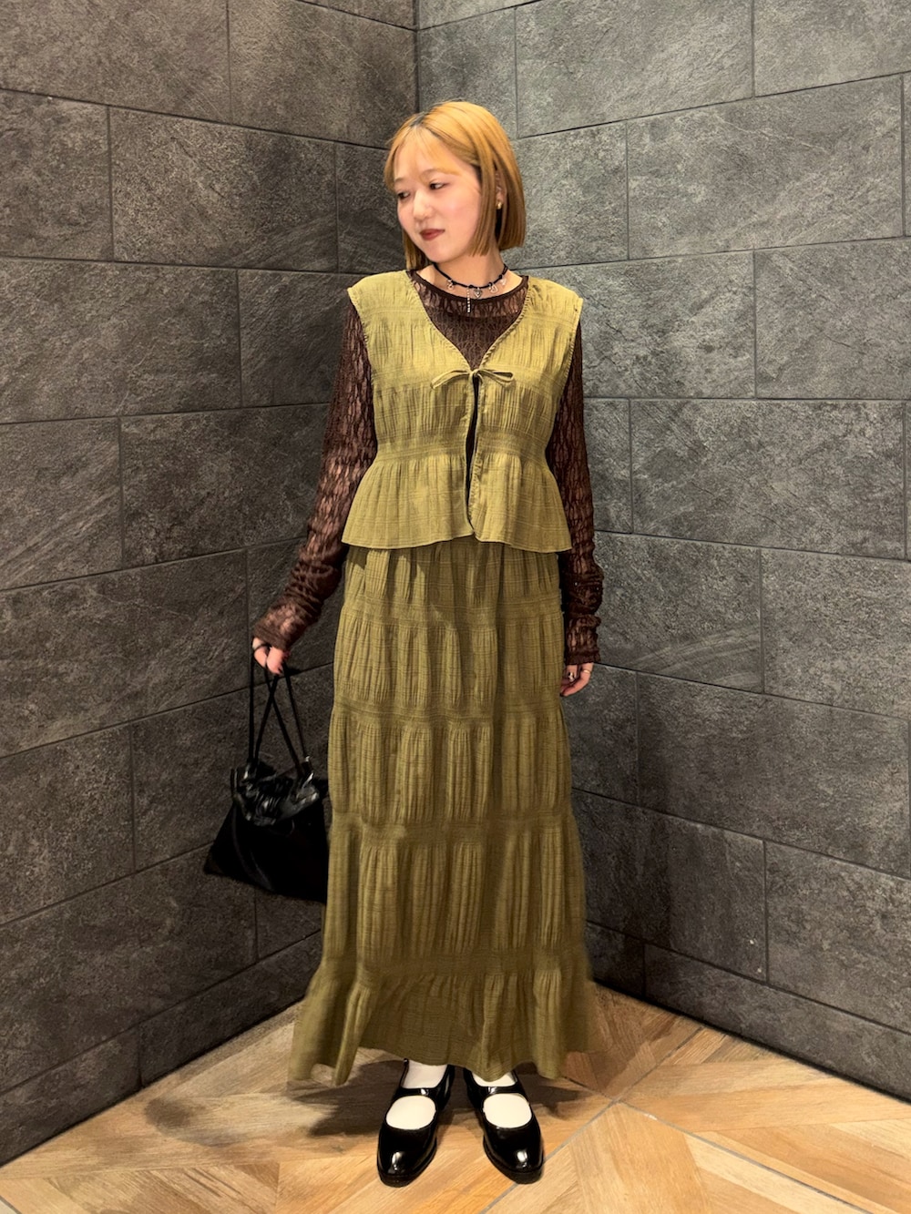 ブラウン系のTシャツ/カットソー、ブラック系のローファー、ブラック系のショルダーバッグを着用したレディースの冬コーディネートの5枚目の写真