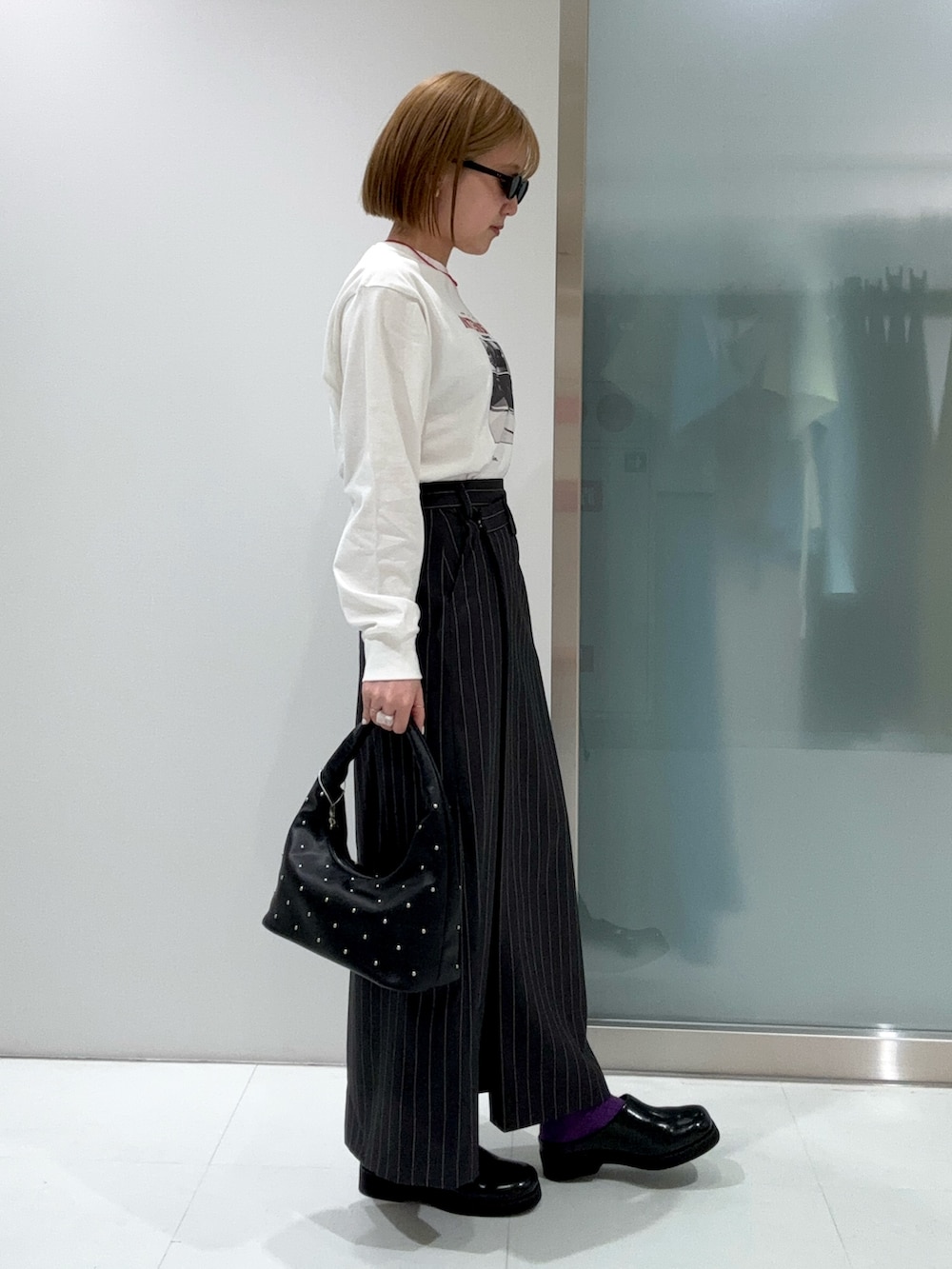 グレー系のスカート、その他のTシャツ/カットソー、ブラック系のハンドバッグを着用したレディースの春コーディネートの3枚目の写真