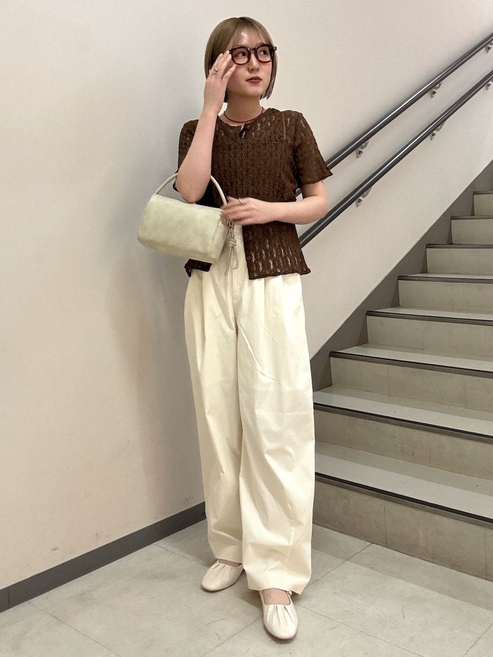 ブラウン系のTシャツ/カットソー、ホワイト系のその他パンツ、ベージュ系のハンドバッグを着用したレディースの春コーディネートの3枚目の写真