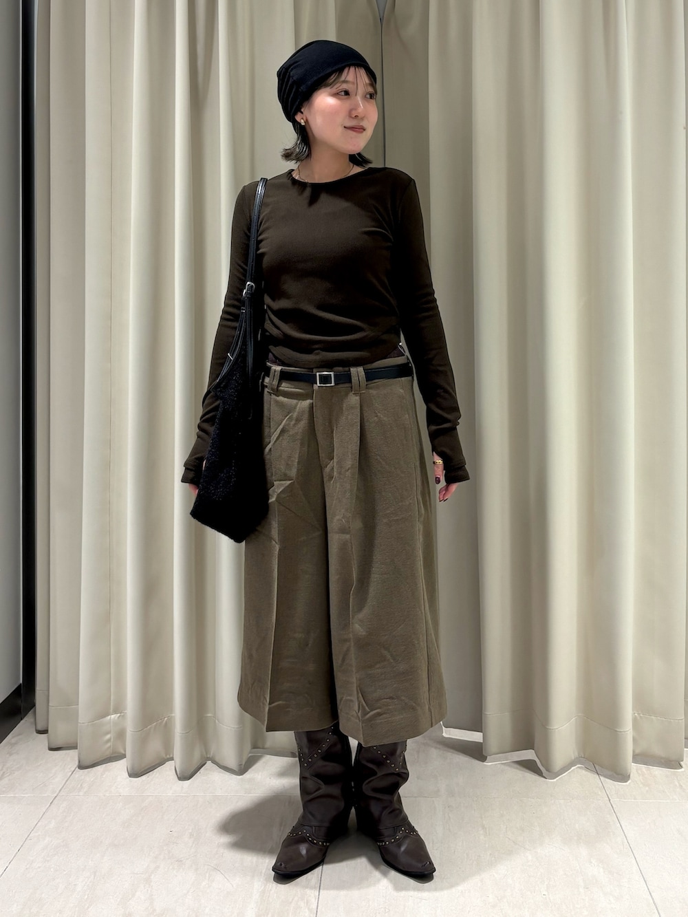 グリーン系のTシャツ/カットソー、ベージュ系のその他パンツ、ブラック系のショルダーバッグを着用したレディースの秋コーディネートの2枚目の写真